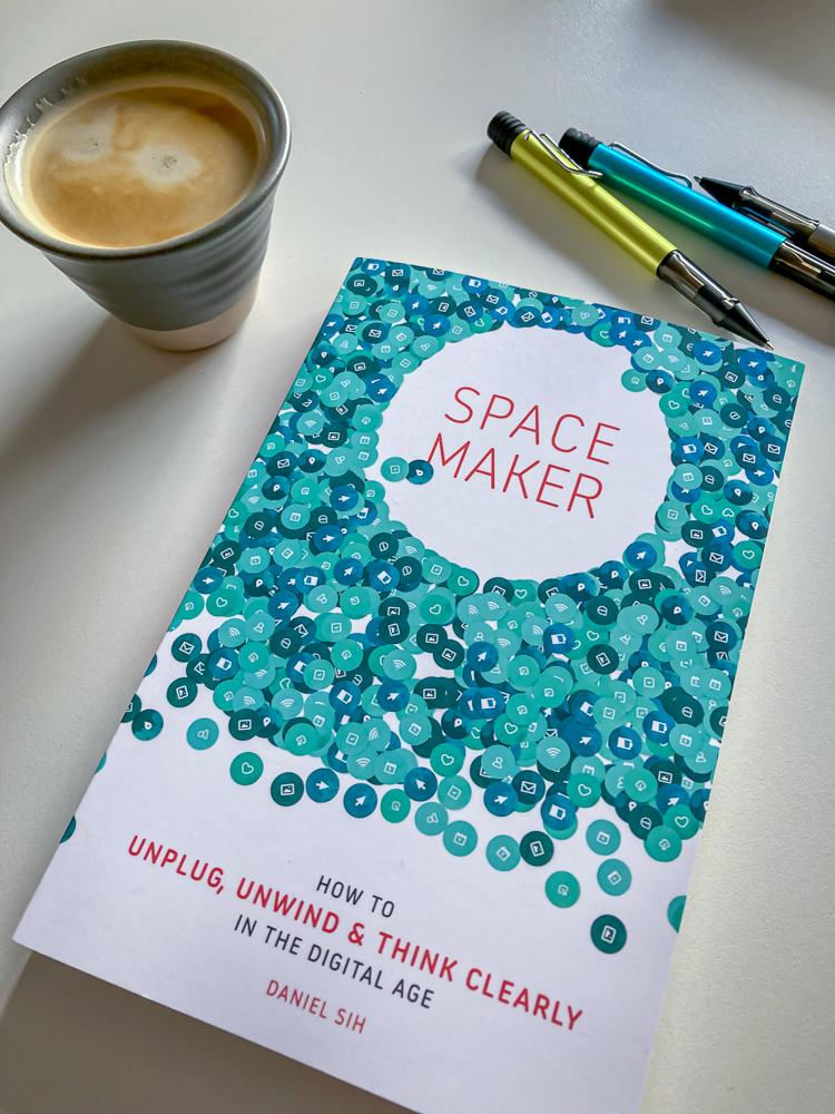 The book Spacemaker by Daniel Sih on a desk with two Lamy pens and a cup of coffee