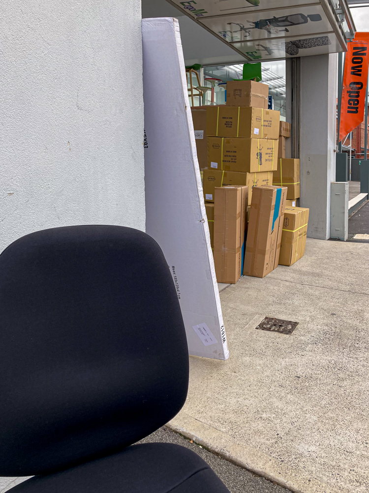A black office chair outside a furniture warehouse