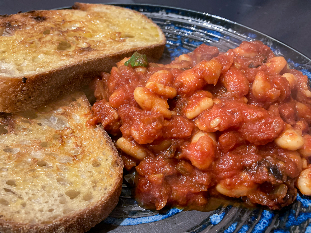 Baked beans on a blue plate with two slices of toast