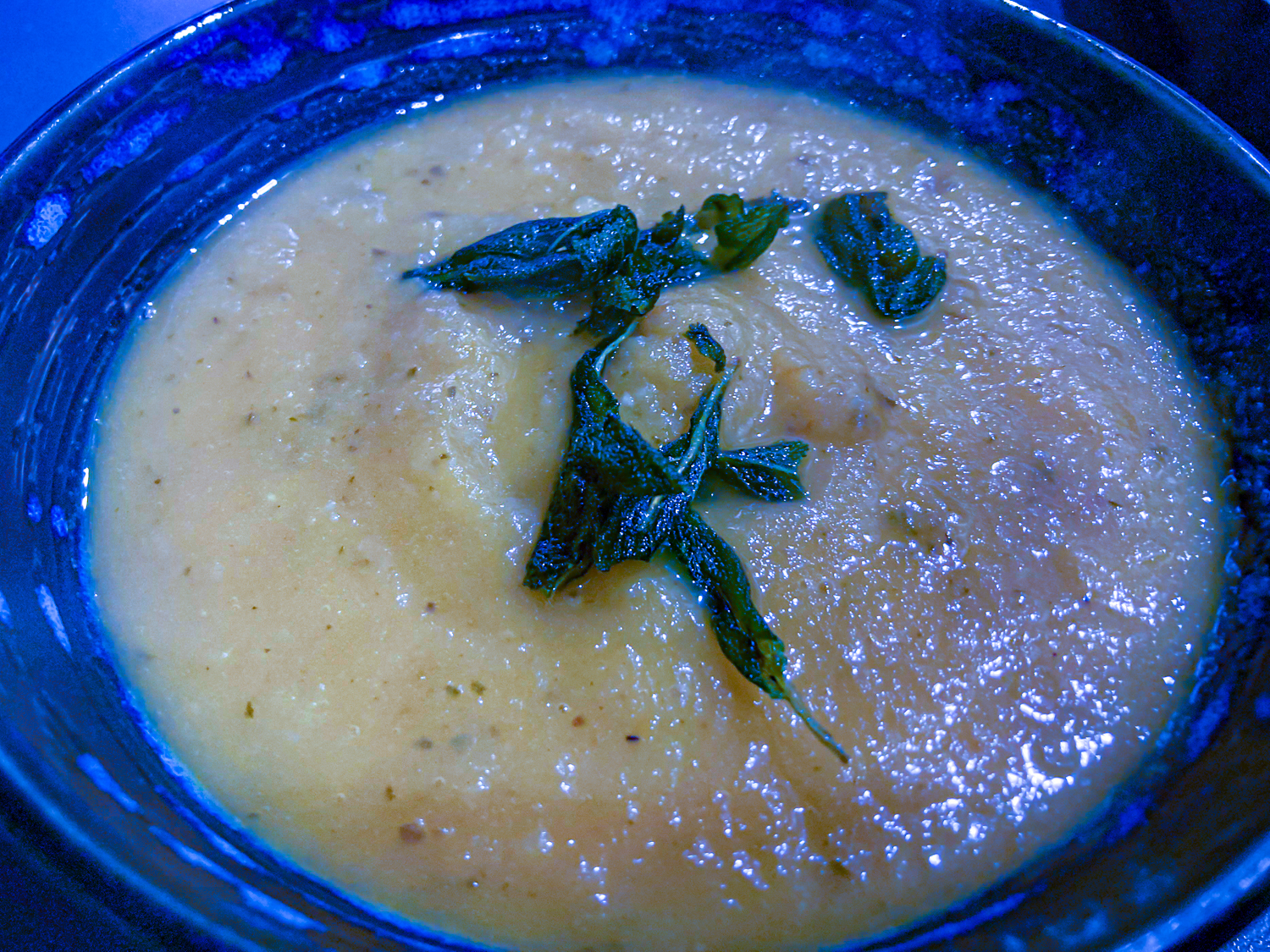 Roast Jerusalem artichoke and tomato soup toped with sage leaves