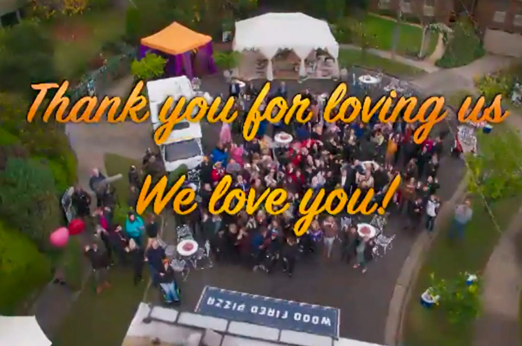 Text "Thank you for loving us. We love you too" over a scene of a street party