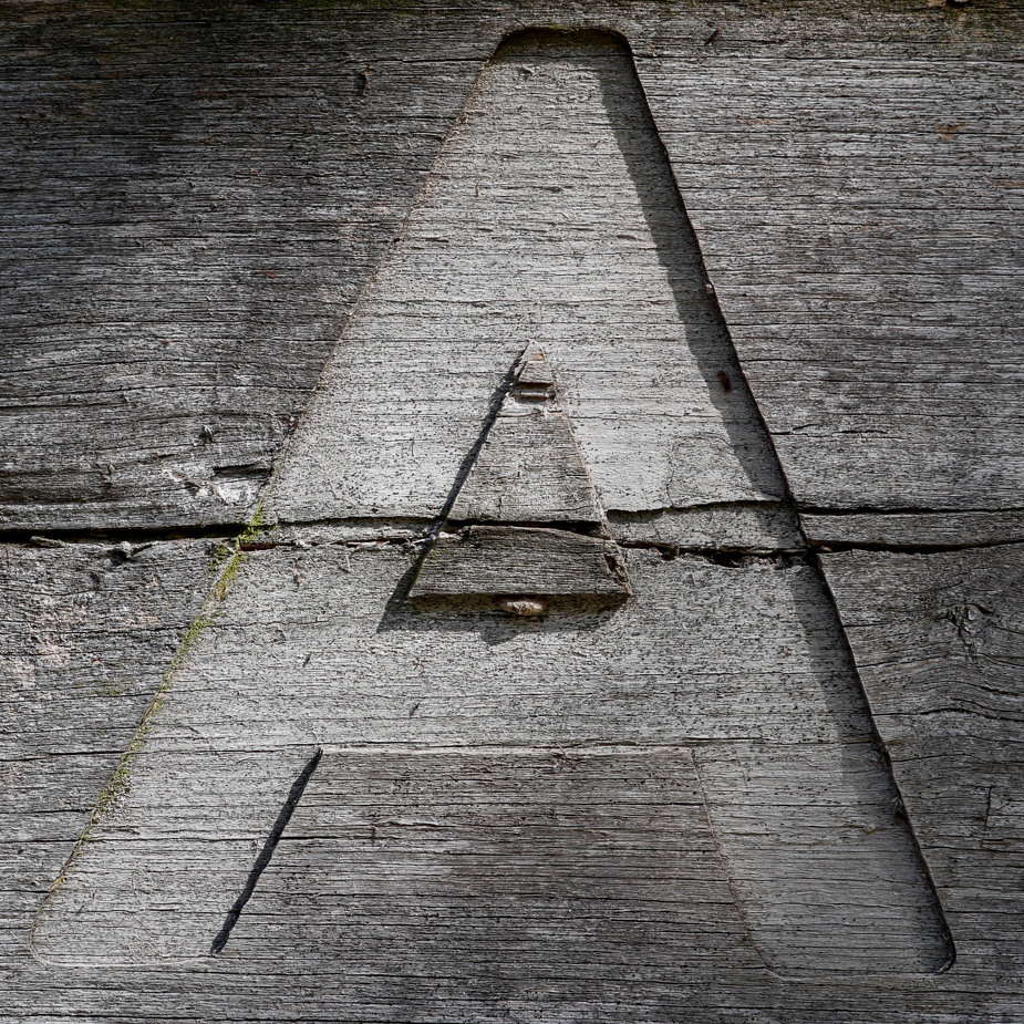 A capital letter A carved into wood