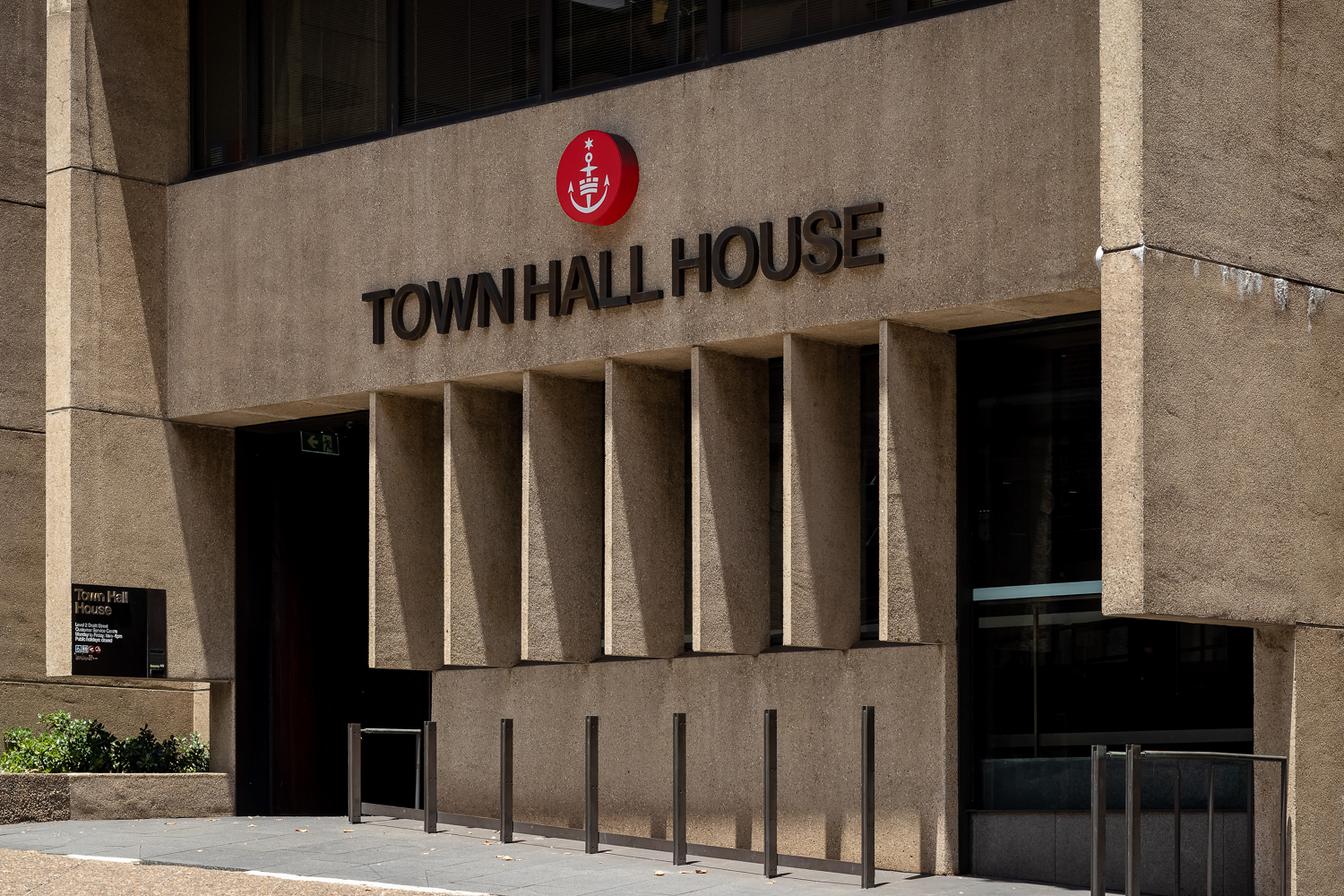 The front of a concrete building with concrete fins outside and the words TOWN HALL HOUSE