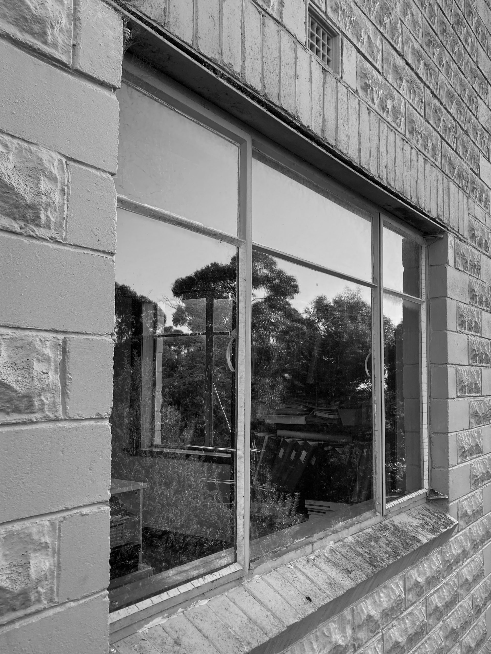 Black and white photo of 1950a windows in a brick house