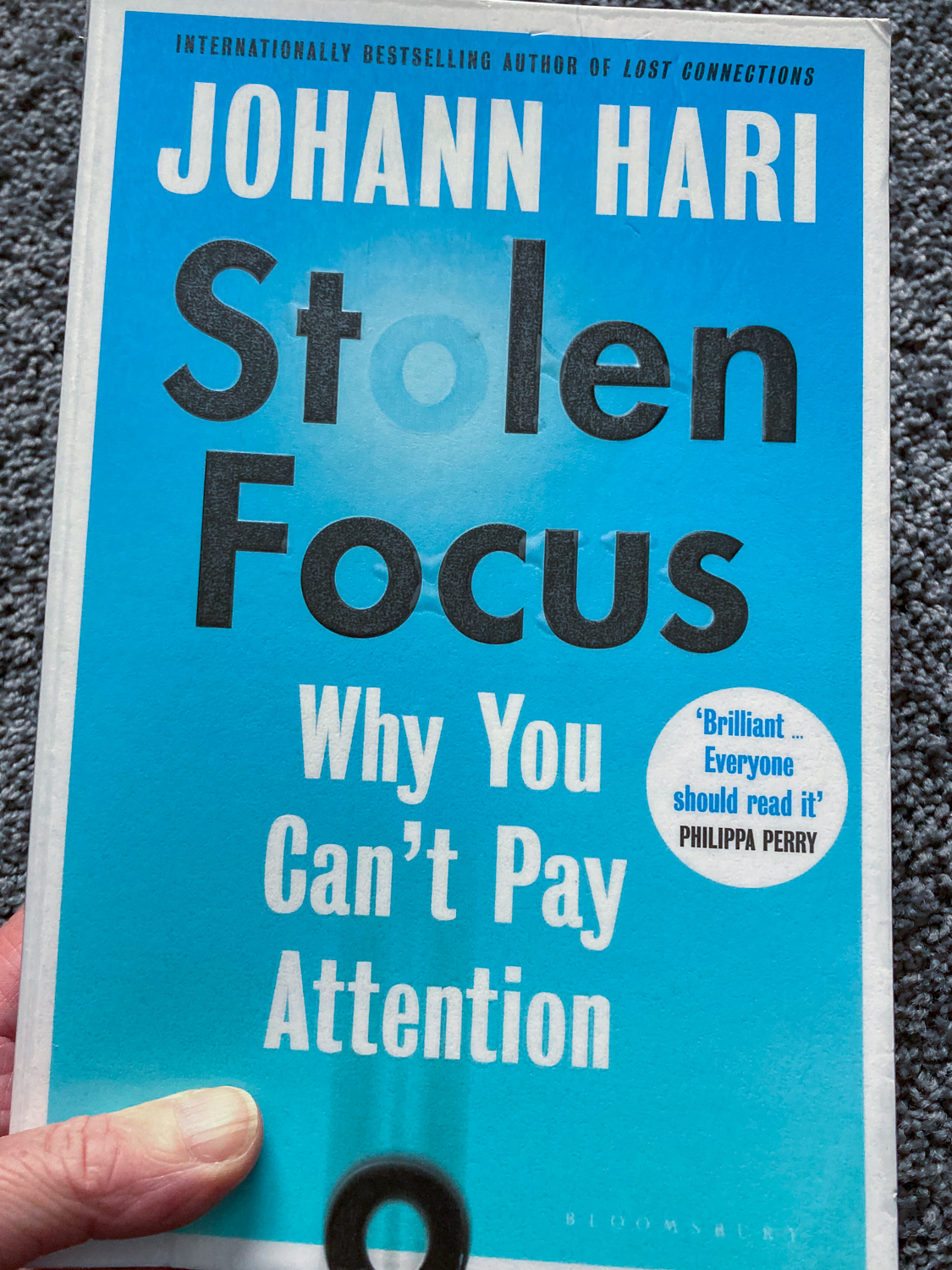 A blue book called Stolen Focus by Johann Hari: Why you can't pay attention