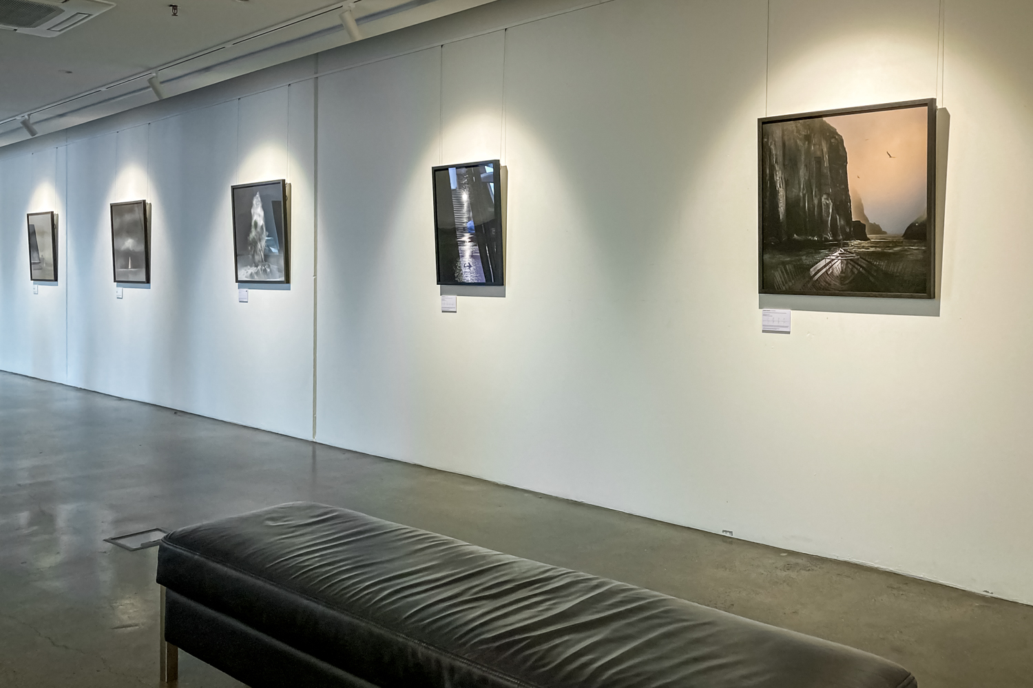 A white gallery wall with a series of fourmaritime images