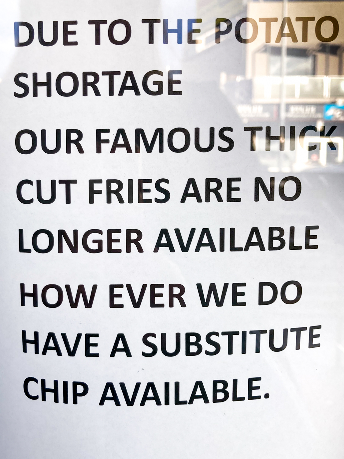 a black and white sign advising that thick cut fries are not available due to the potato shortage but that there is a substitute chip available