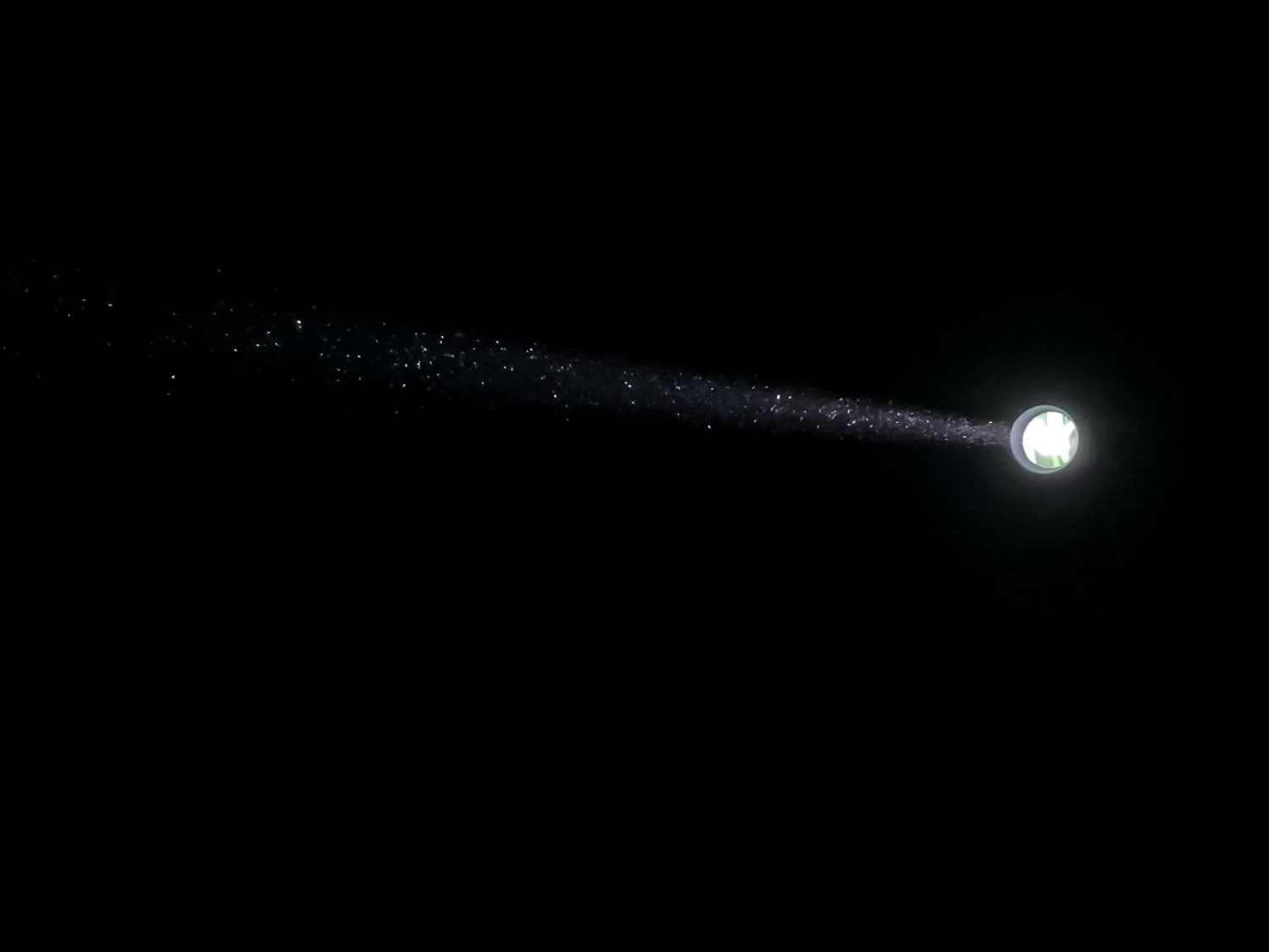 A dust-filled beam of light against a black background
