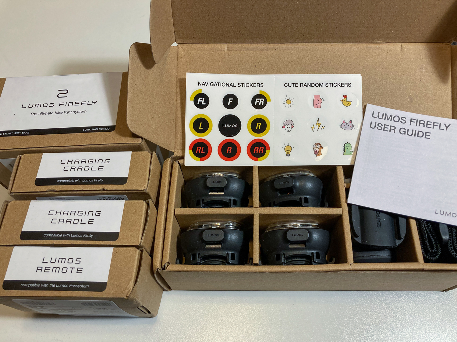 A box of small bike lights next to four unopened small boxes with accessories for the lights