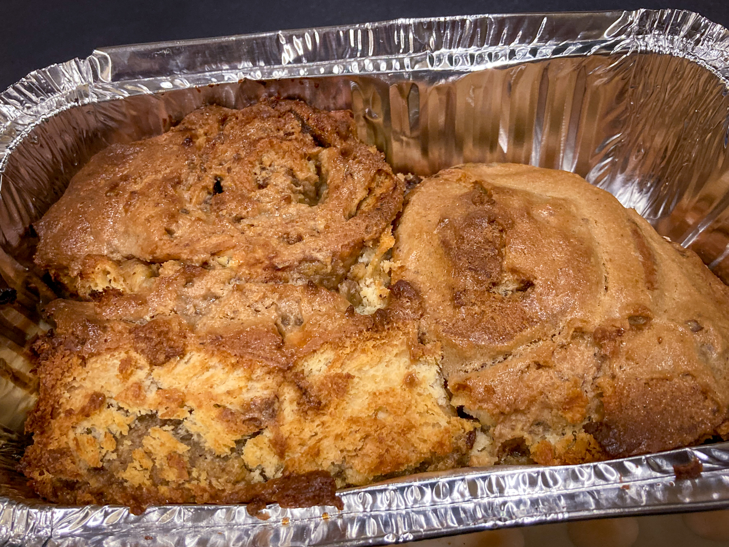 A foil container containing some baked goods