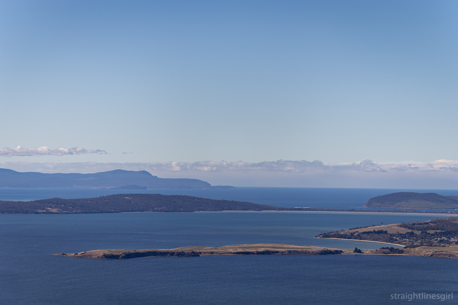 A view of water, land masses and blue sky