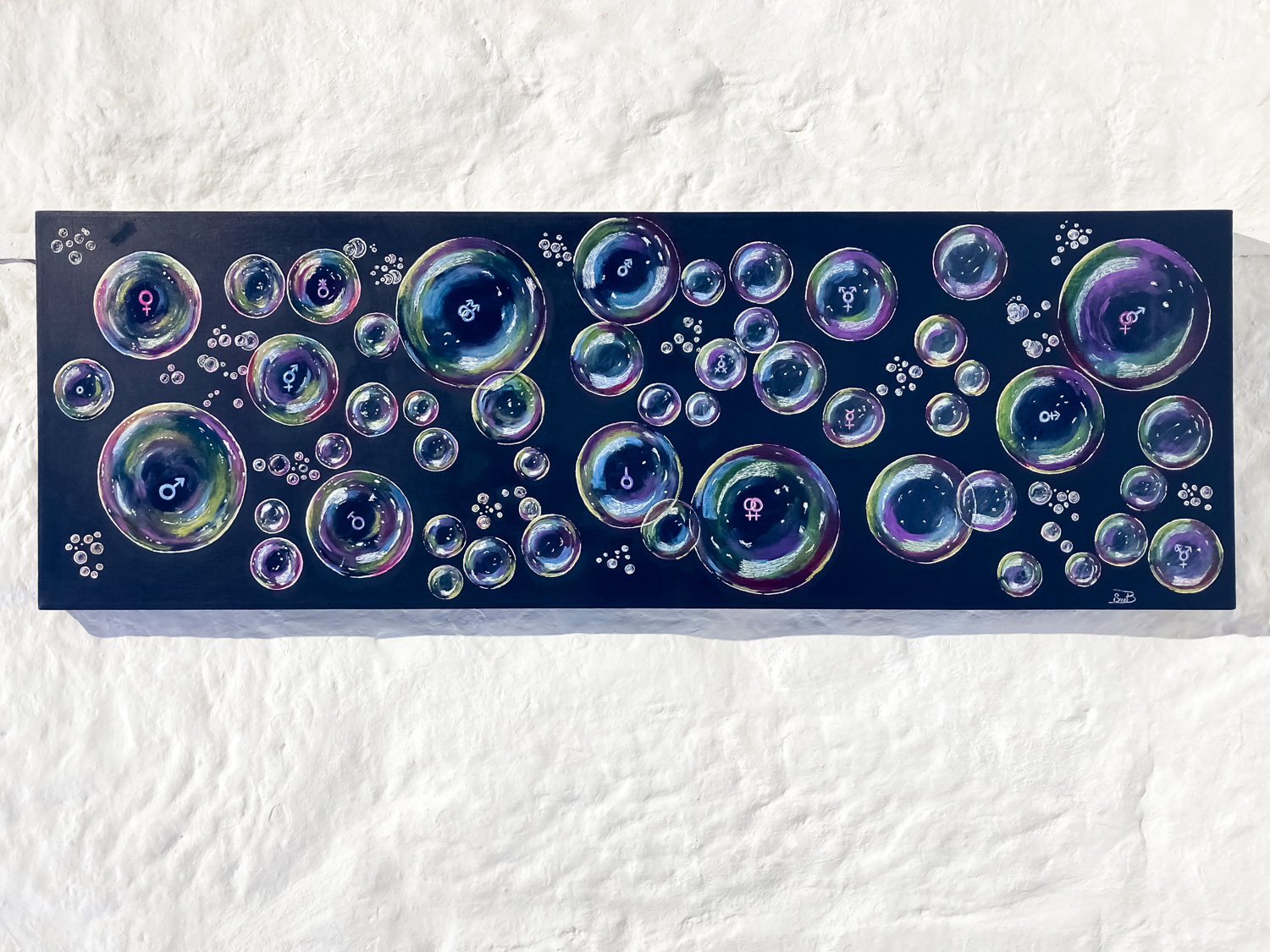 A painting of coloured bubbles of varying sizes, some with gender and relationship symbols, on a black background, hanging on a white wall