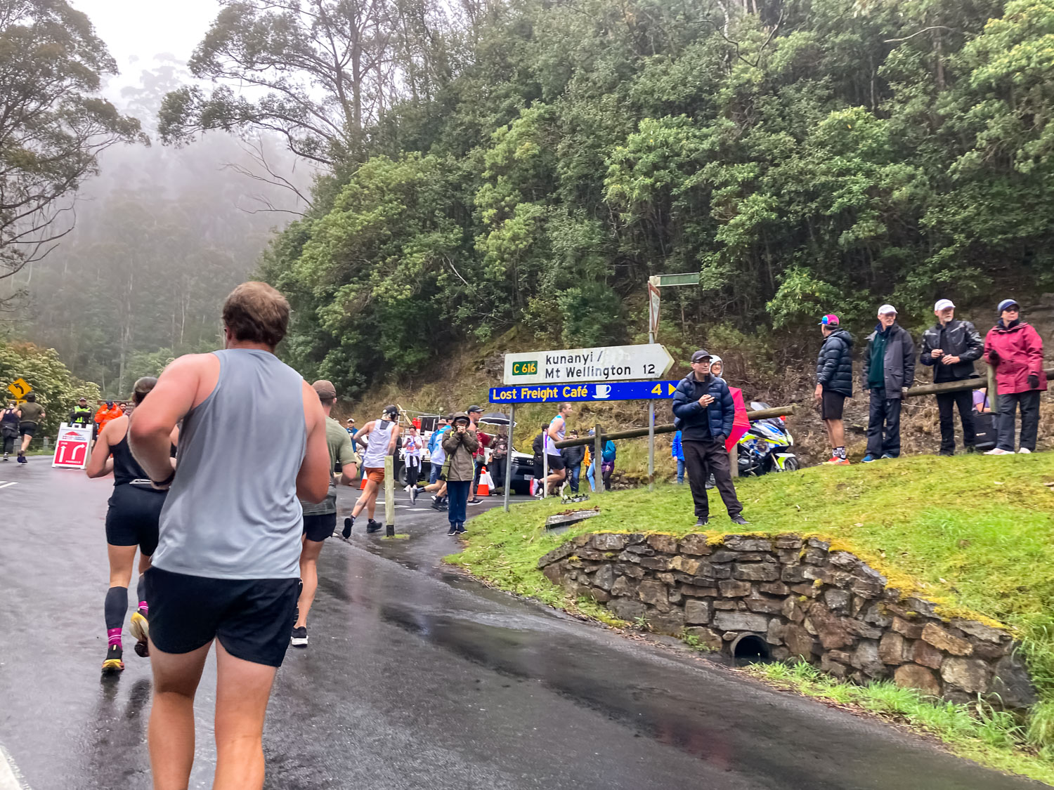 A group of walkers approaching a turn off to kunanyi/Mt Wellington in the mist
