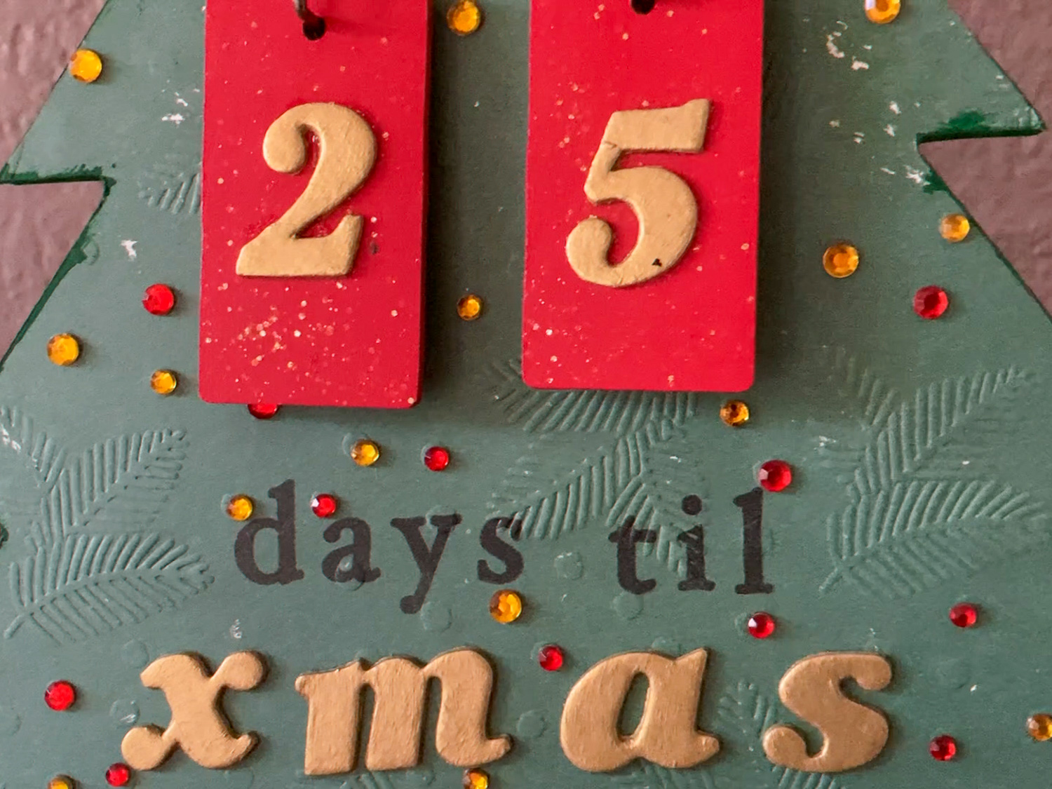 A green background with gold numbers 2 and 5 on red tiles, and the words "days til xmas"