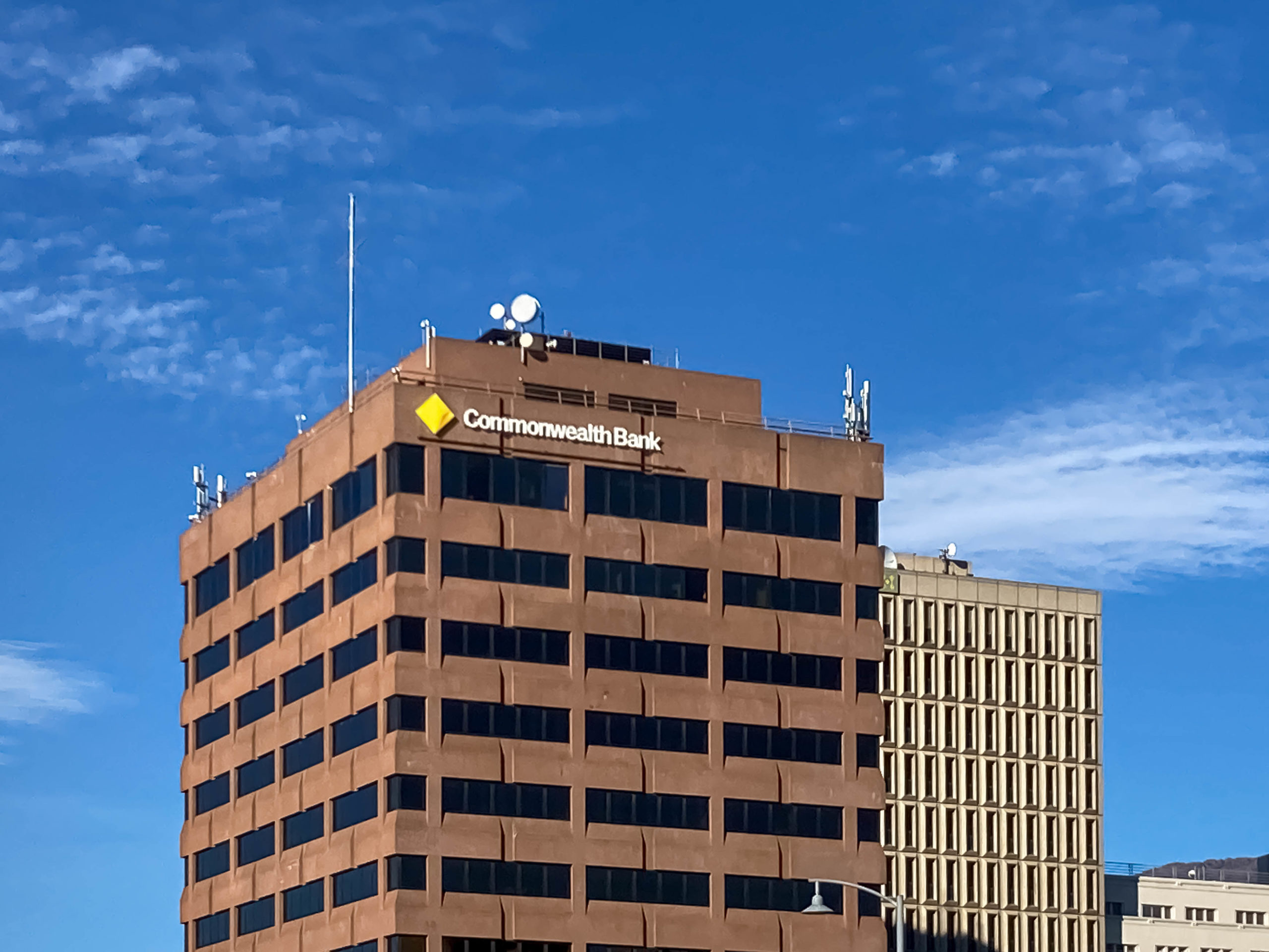 A brown modernist building with the Commonwealth Bank logo prominently displayed at the top