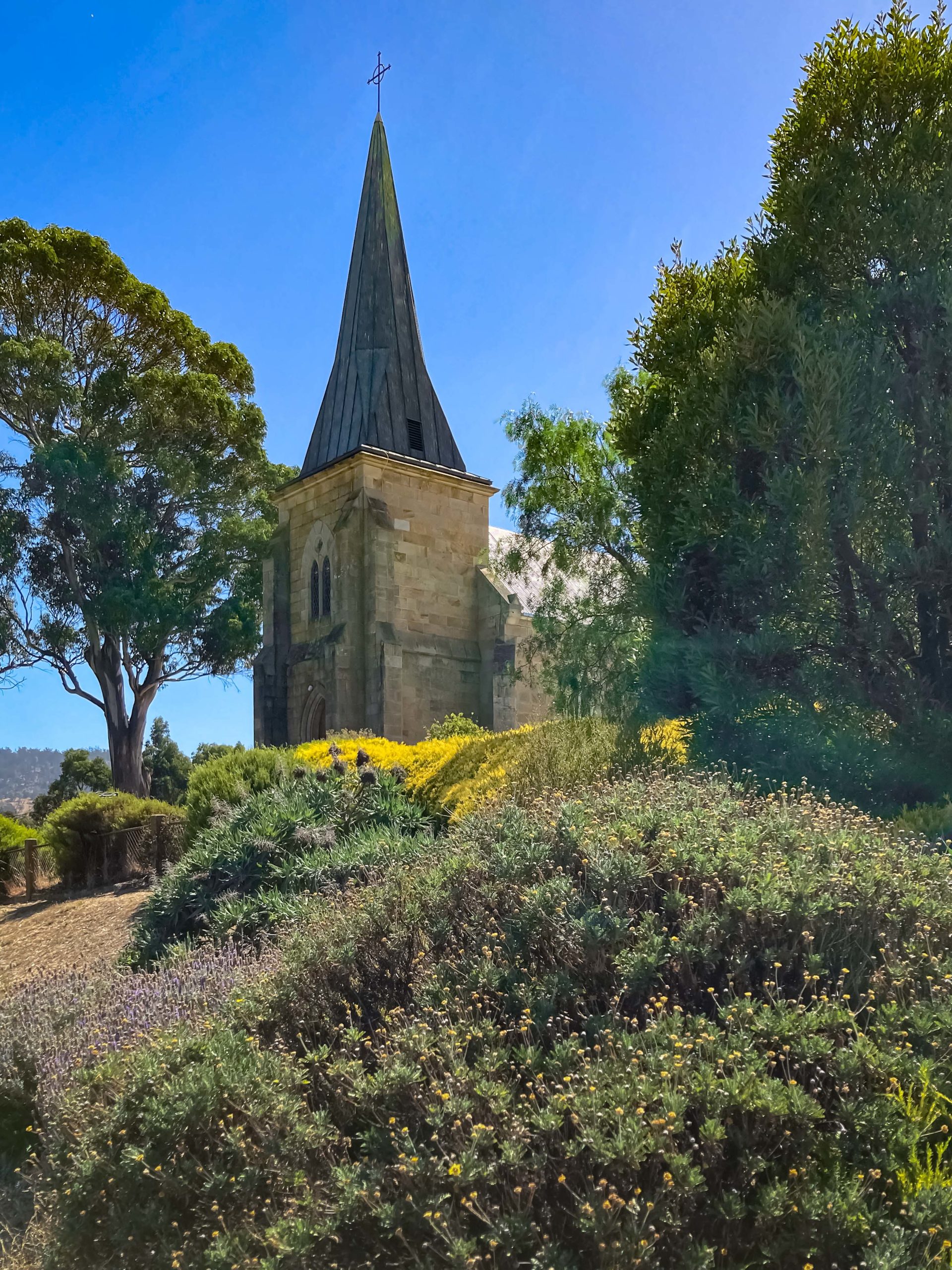 An old sandstone church surrounded by vegetation