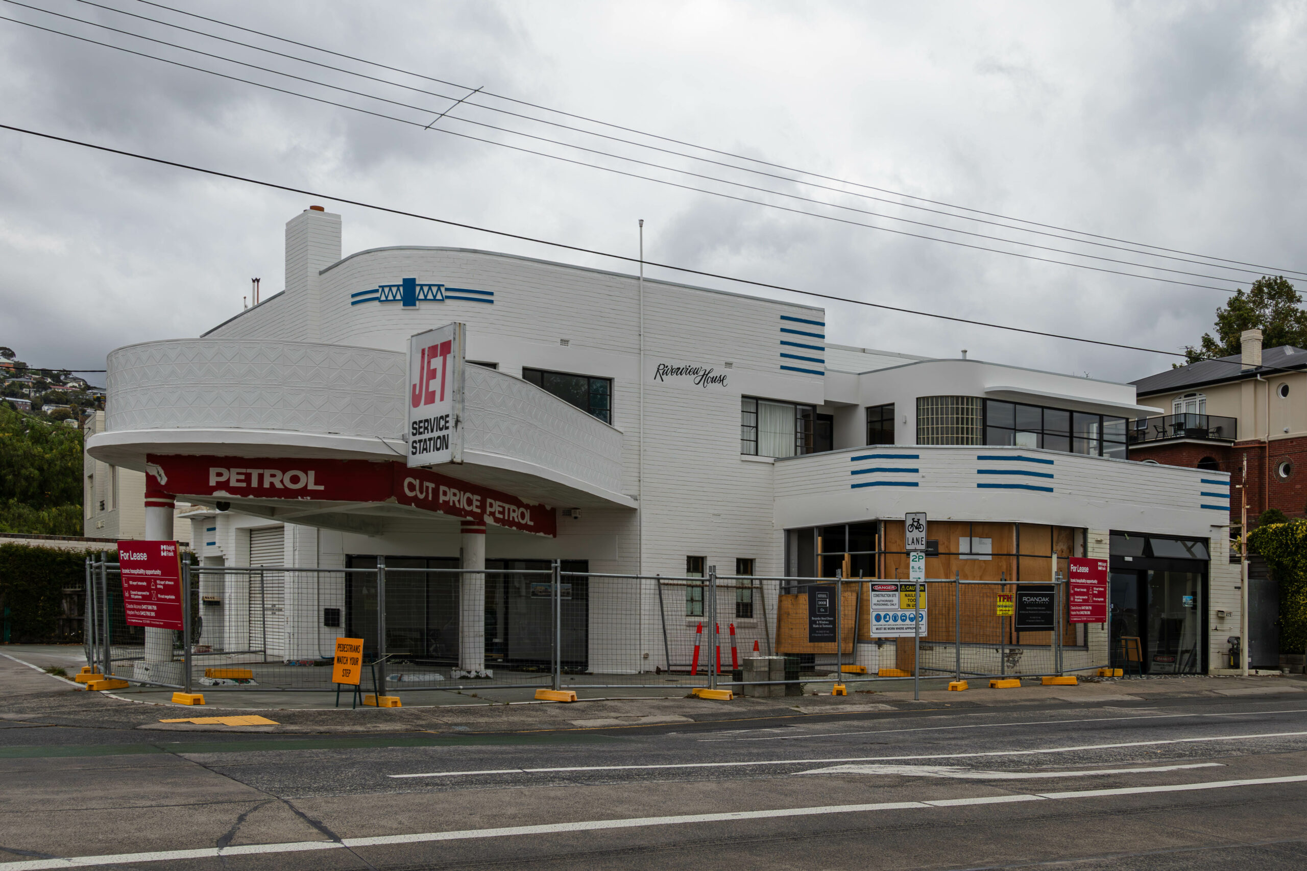 An art deco service station painted in white with blue trim undergoing renovations