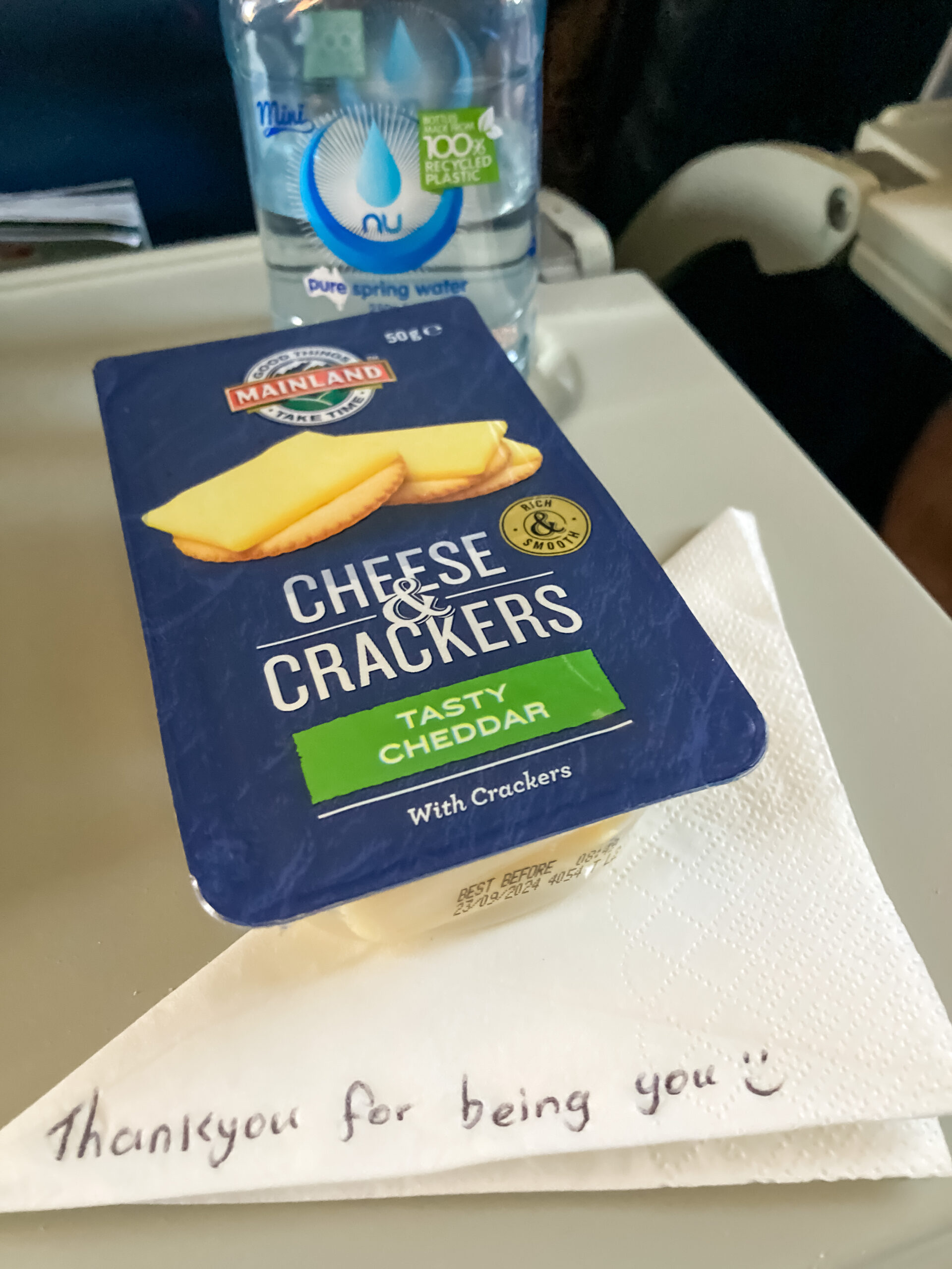 A snack pack of cheese and crackers sitting on a serviette on which the words 'thank you for being you' are written