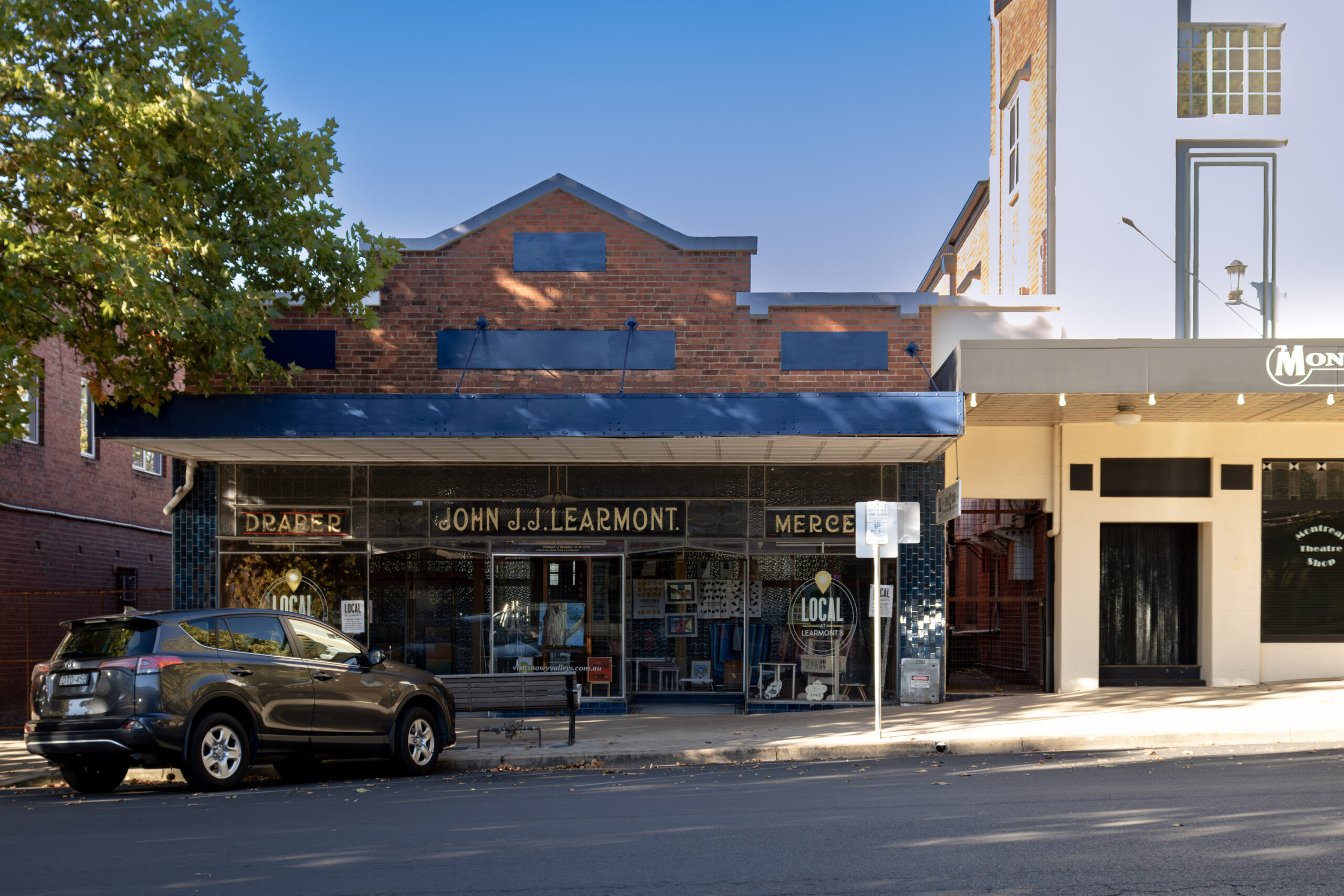 A storefront of a mid-20th centry drapery store with the title John JJ Learmont