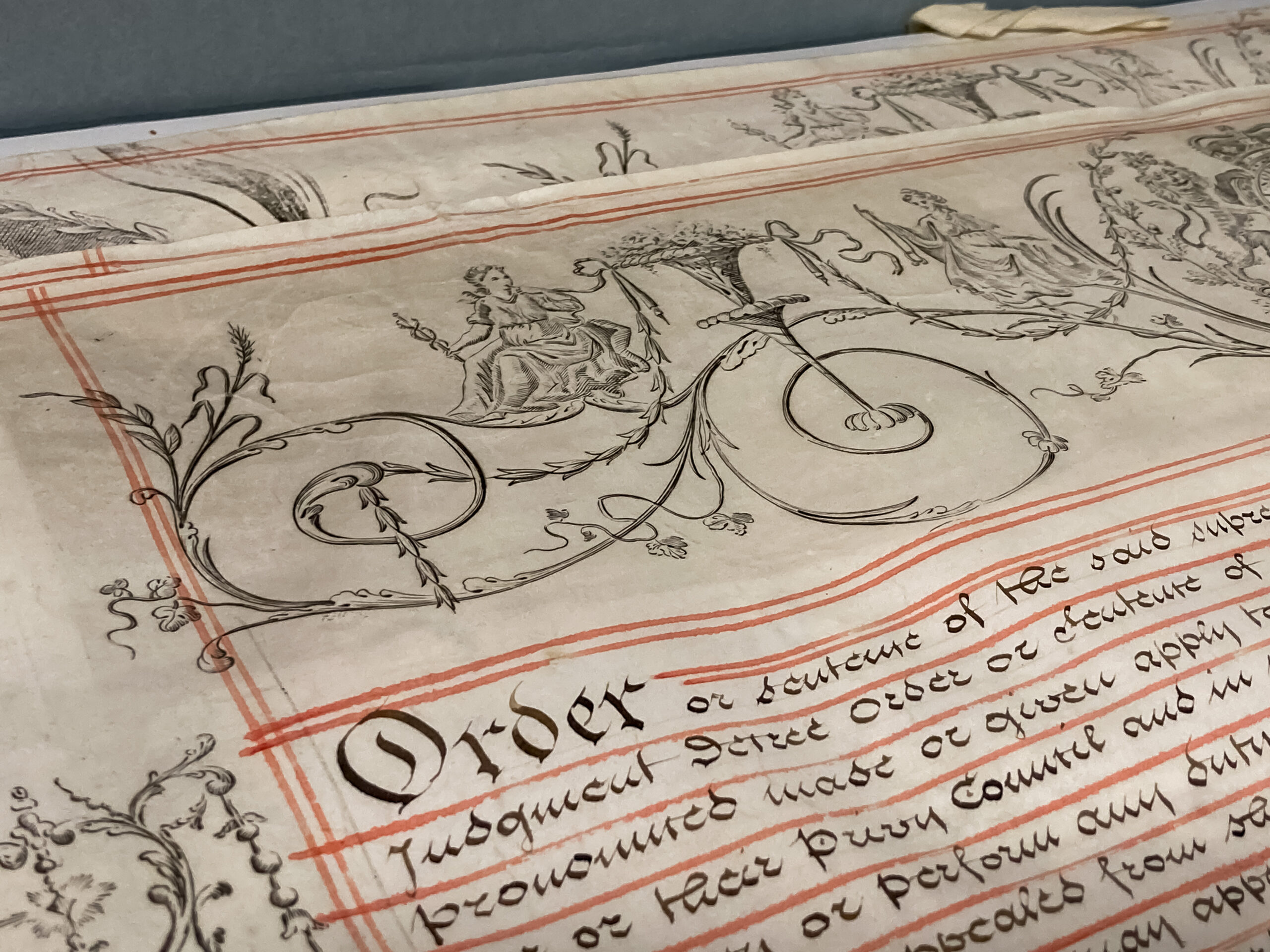 A close up image on an old document with ornate decoration beginning with the word "order"