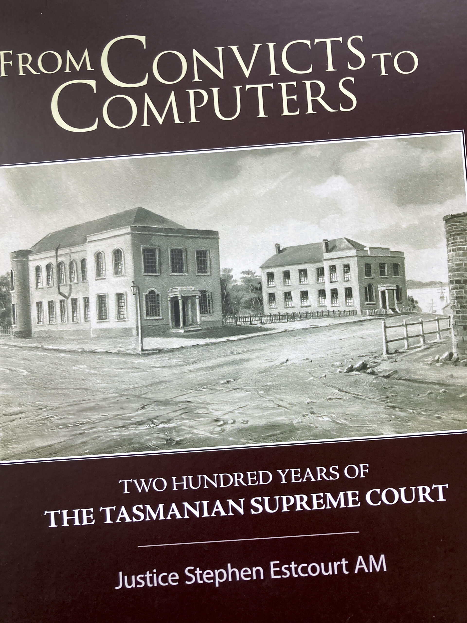 The cover of a book called From Convicts to Computers, Two Hundred Years of the The Supreme Court of Tasmania by Justice Stephen Estcourt. There is a on old picture of two old two-storey sandstone buildings on the cover