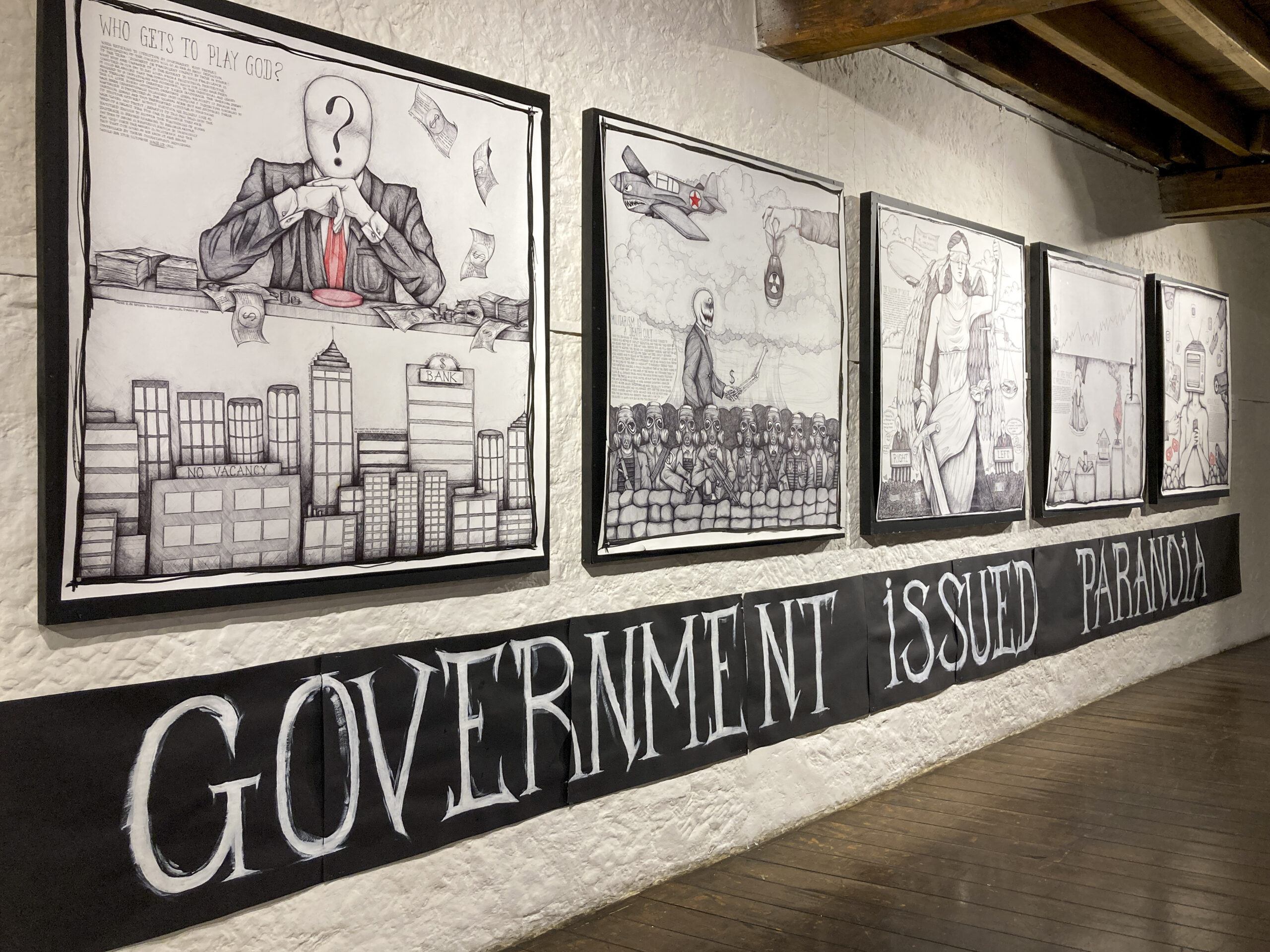 A series of five large black and white pen drawings are mounted on a white wall above a black banner bearing the words GOVERNMENT ISSUED PARANOIA