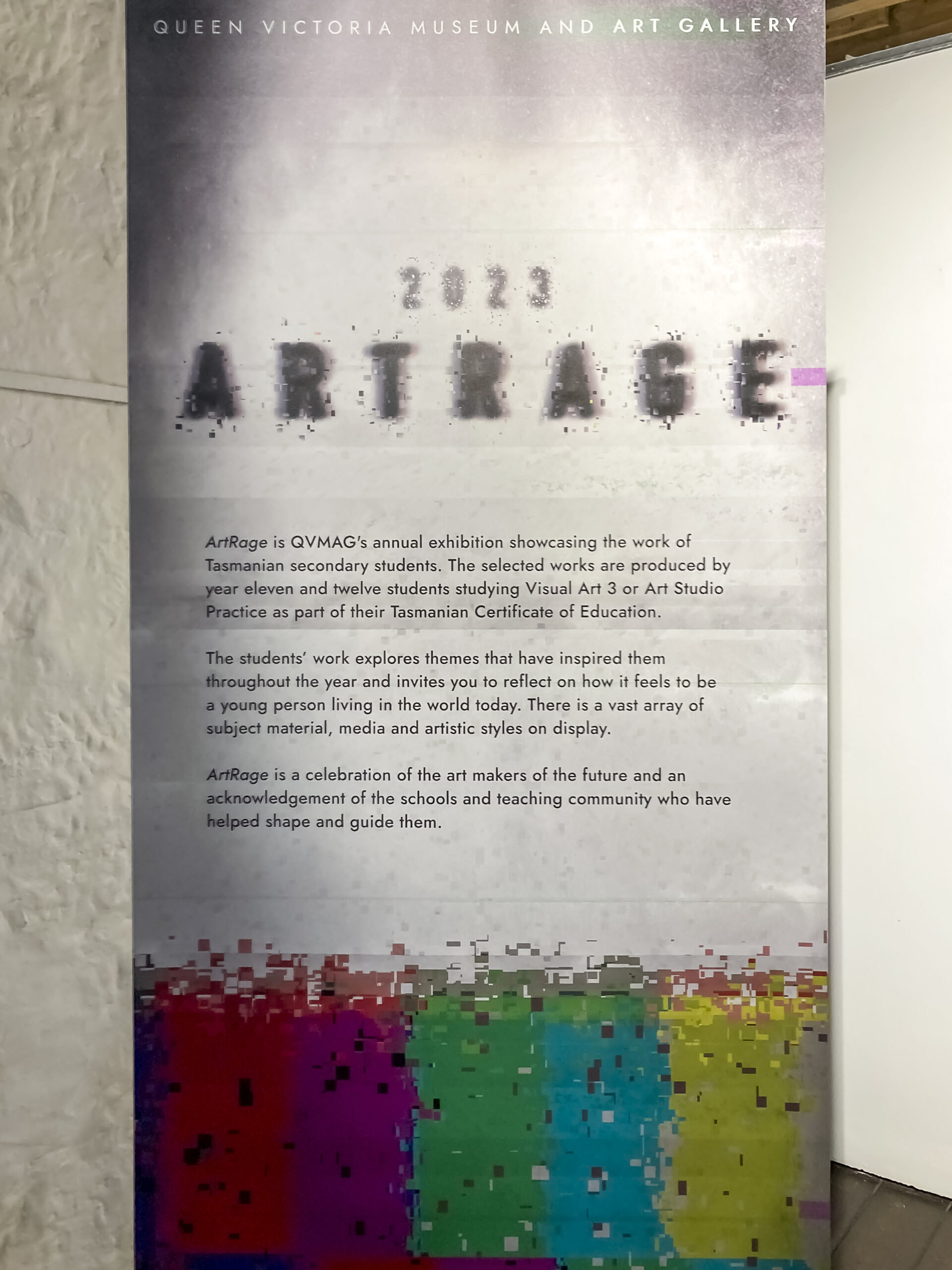 A poster with the words 2023 ArtRage and a description of the exhibition. There are coloured blocks at the bottom of the poster