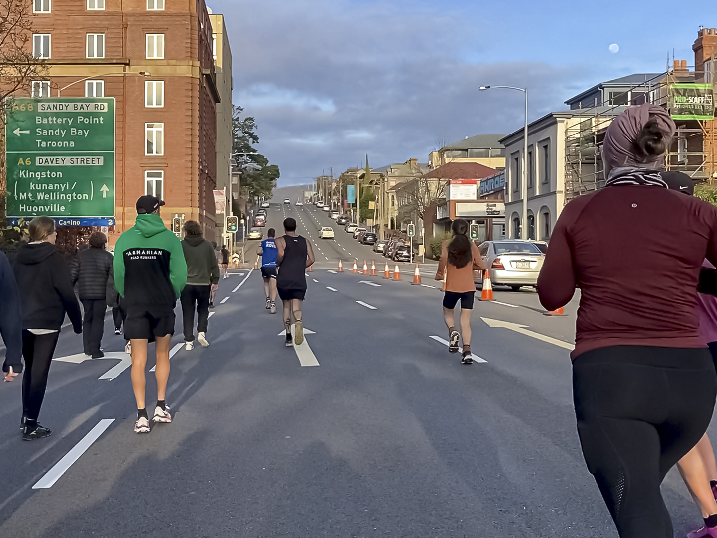 A view of runners from behind on an otherwise empty streeet