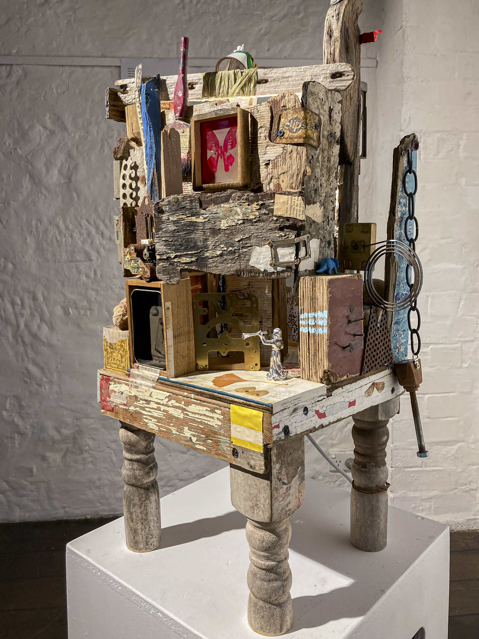 A sculpture made of found objects including a small wooden table