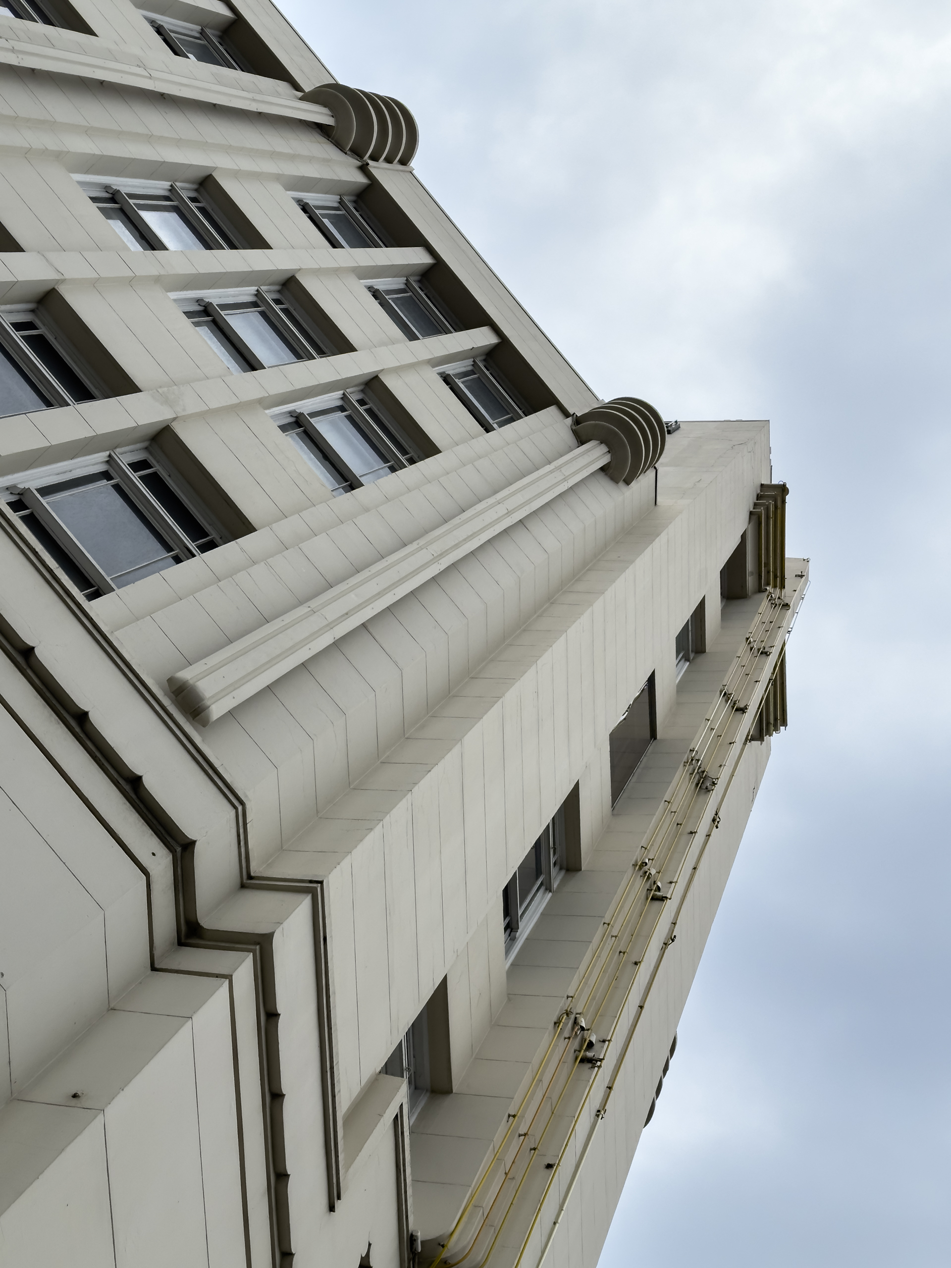 A view looking up at the detail of the facade of an art deco stle building