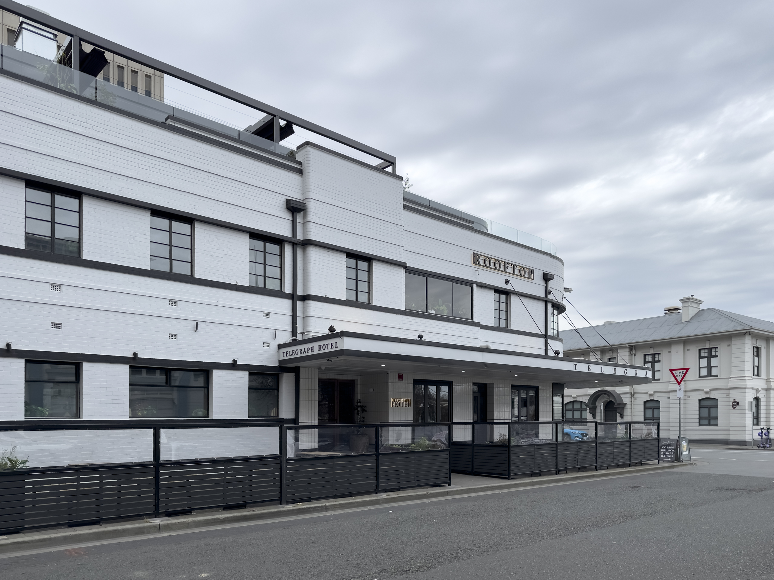 A side view of a newly painted two storey hotel in the art deco style