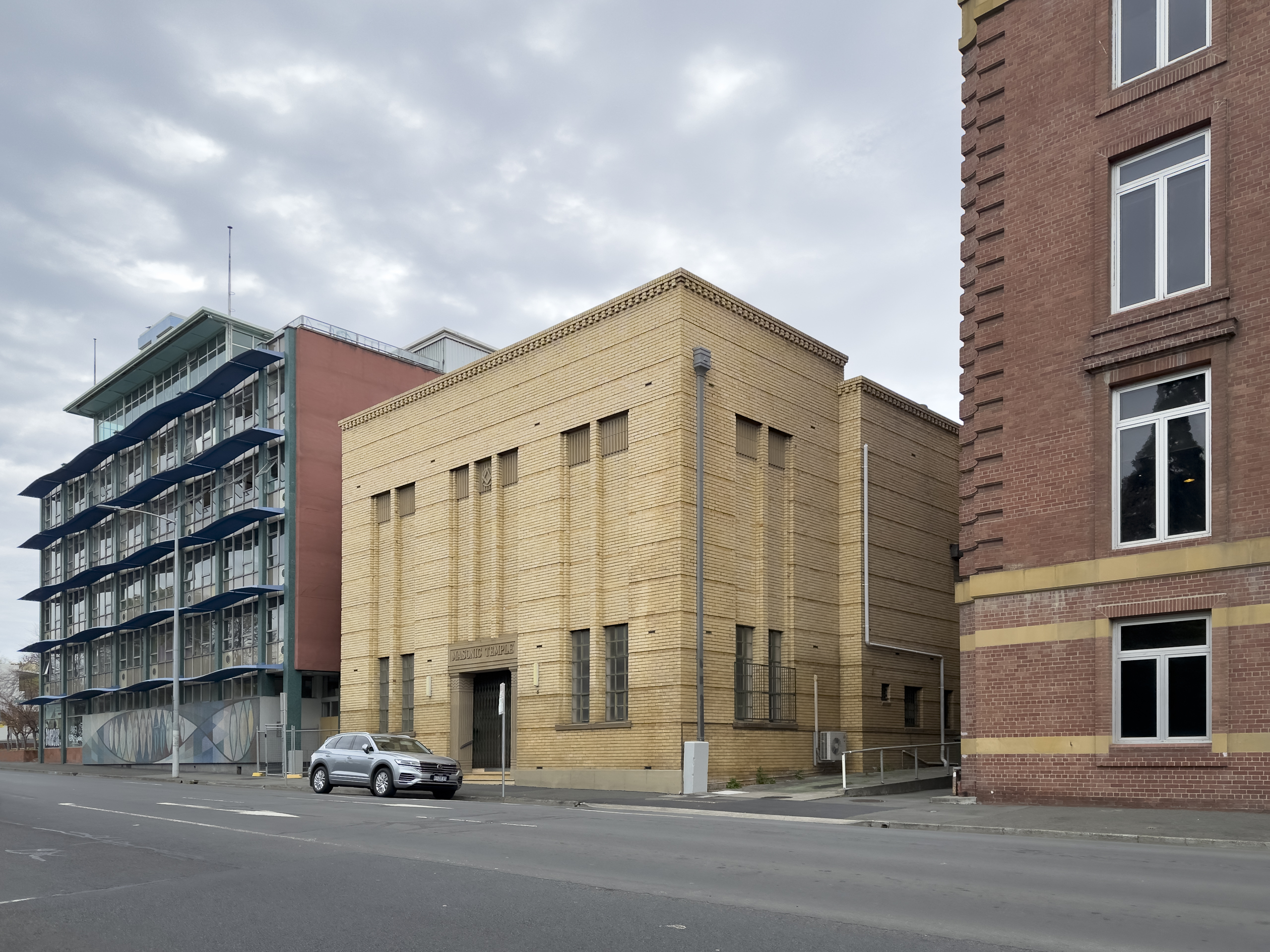 A small, yellow brick building in the stripped classical style