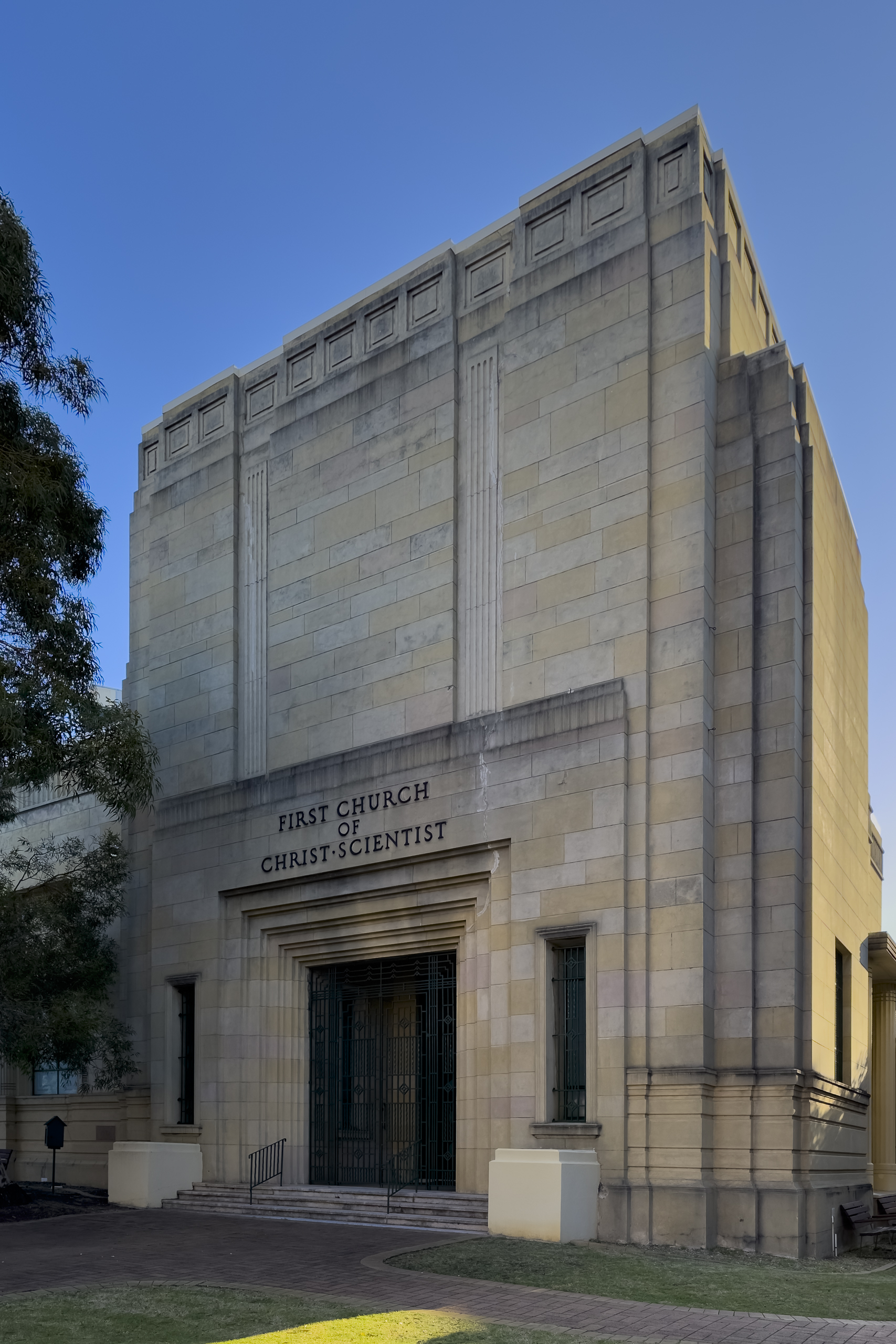 A blocky sandstone building with the words "First Church of Christ Scientist" over the entry