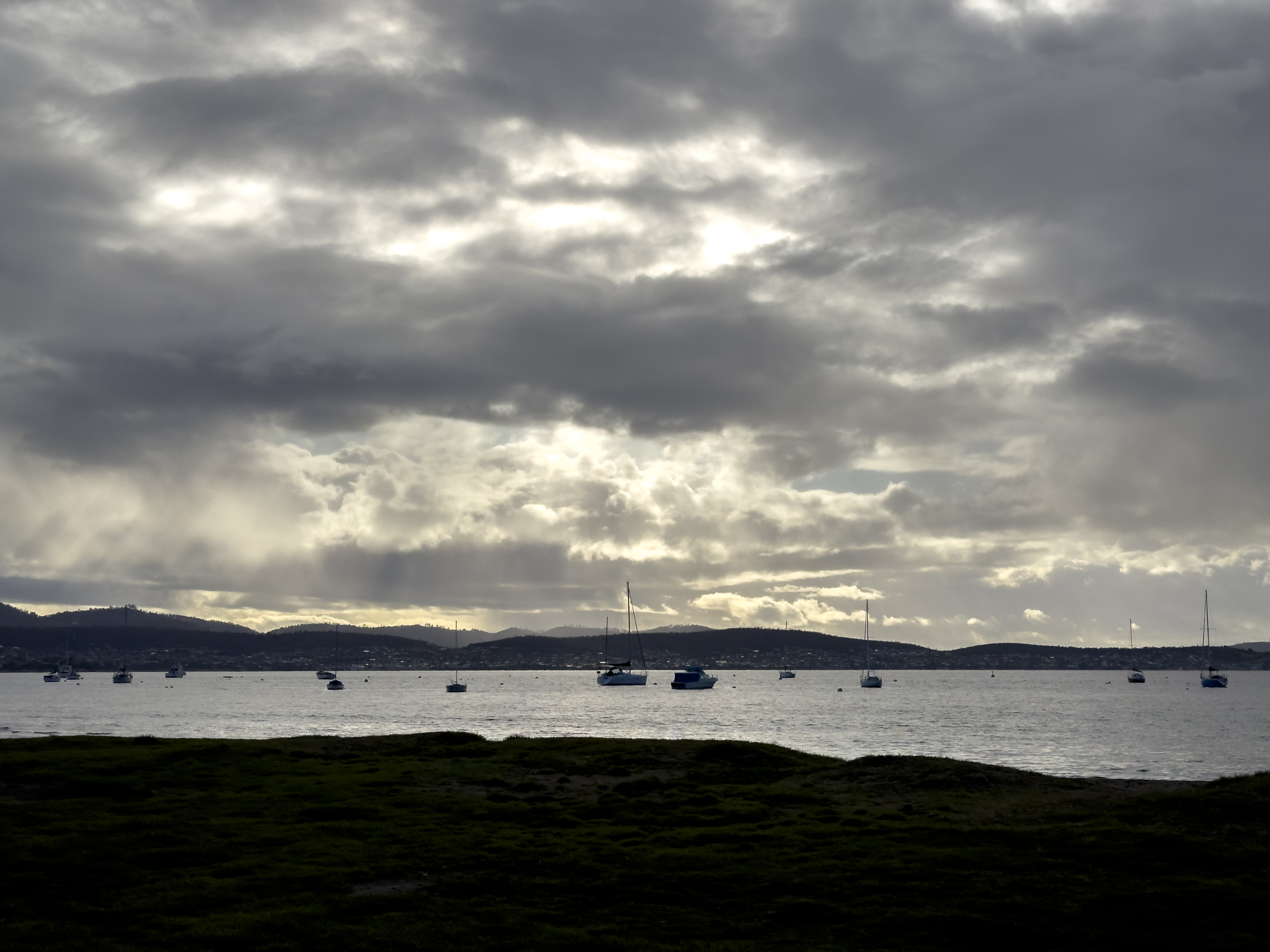 A dark early morning sky with boats on the river