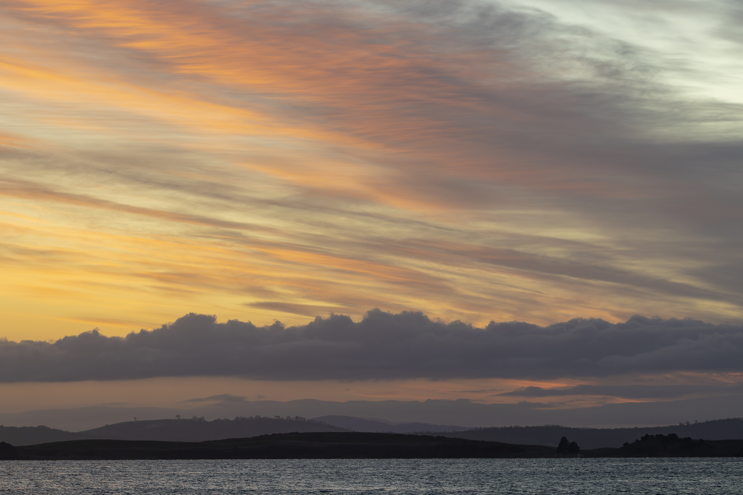 Pale orange clouds in a sunrise sky over the river