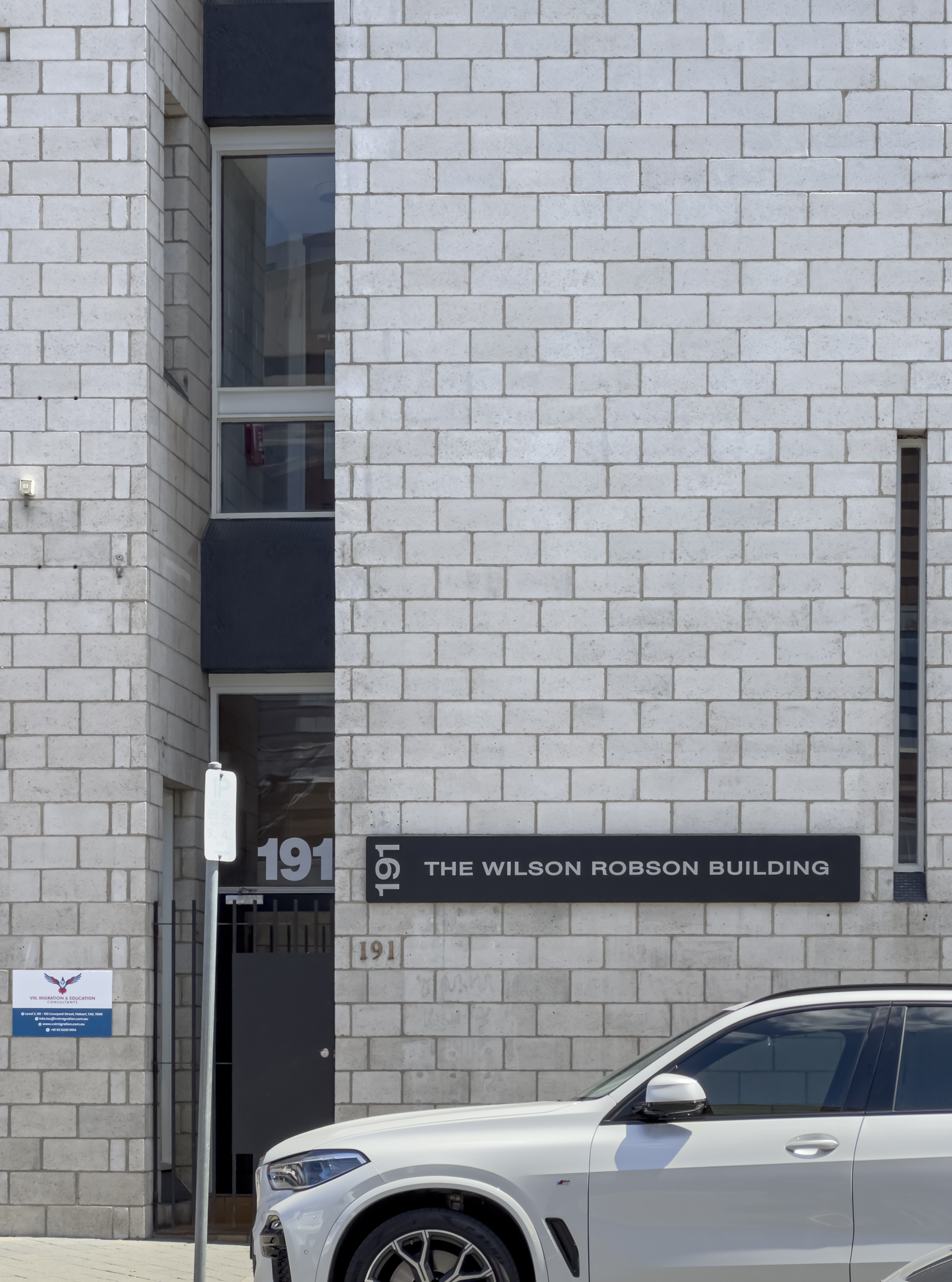 The side wall of a grey brick building with a sign that read ROBSON WILSON BUILDING