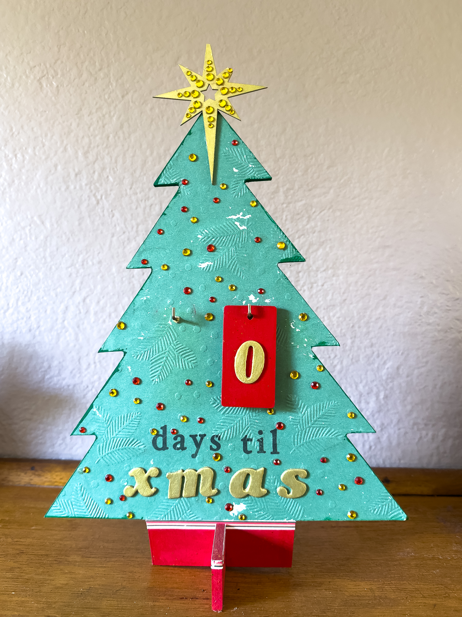 A cutout green christmas tree with a broken yellow star on the top, the number 0 on a red tag and the text 'days til Xmas' at the bottom