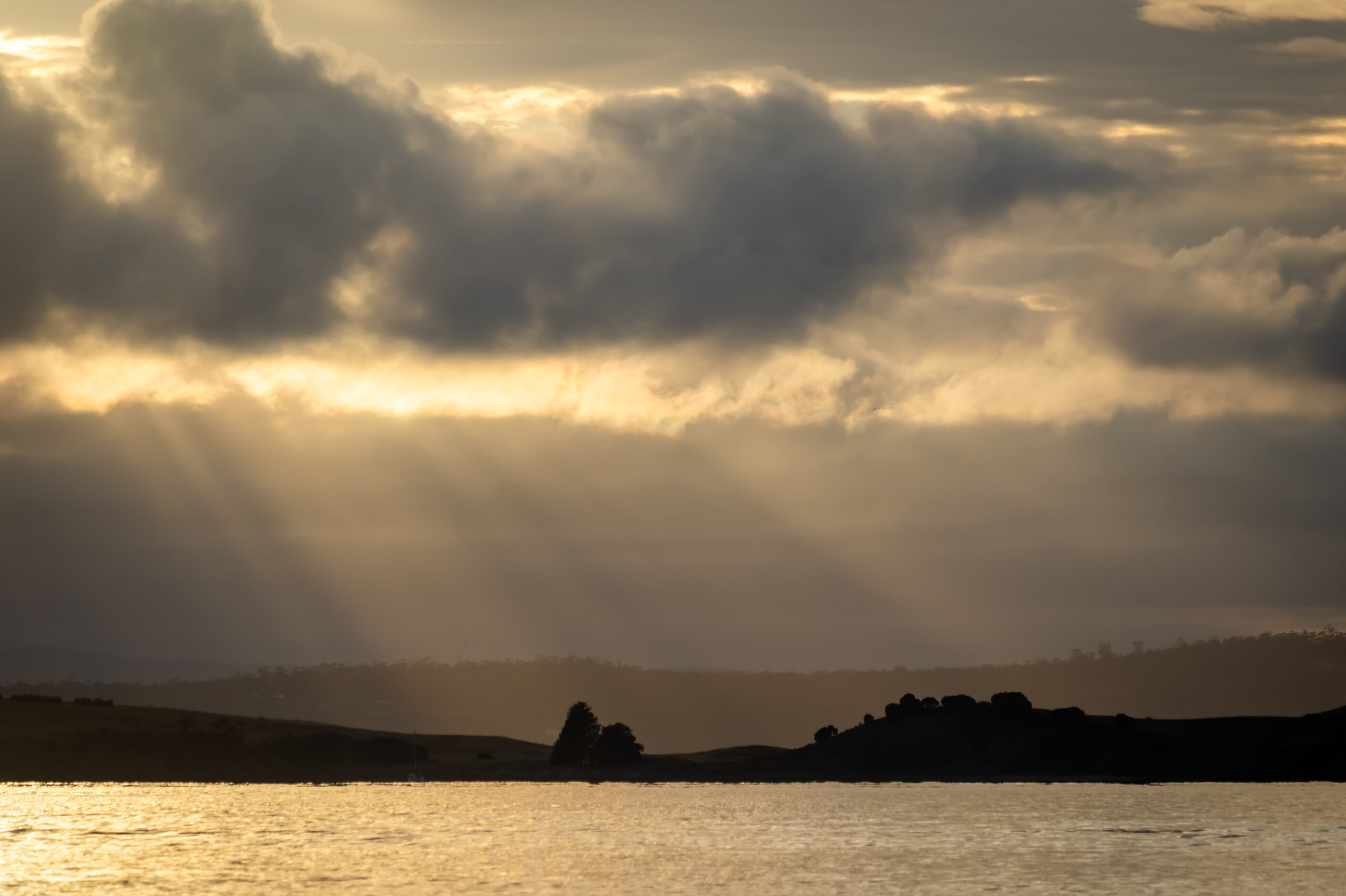 Crepuscular rays from the shaded sunlight onto the river