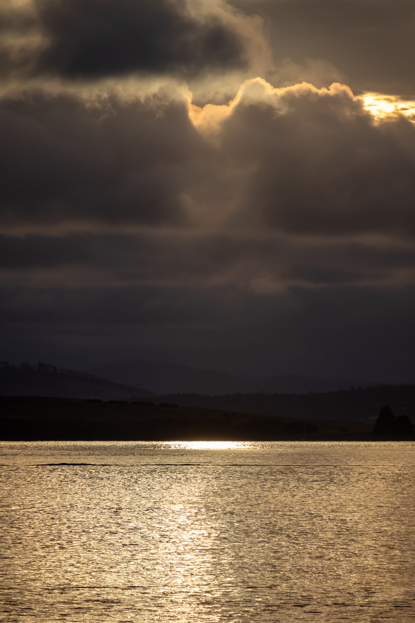 Sunlight reflected through dark clouds on the river