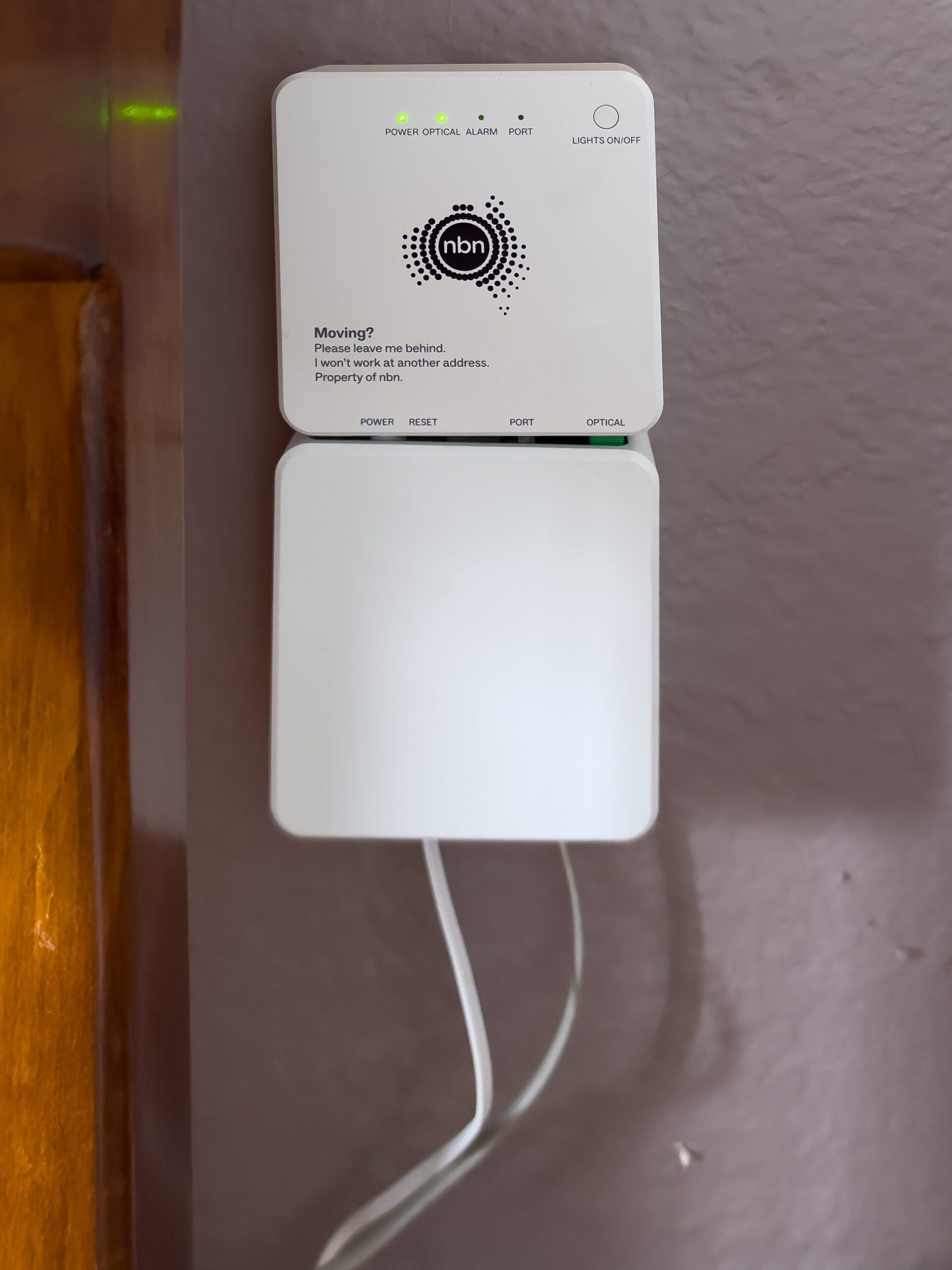 A two-segment white internet box affixed to an internal wall