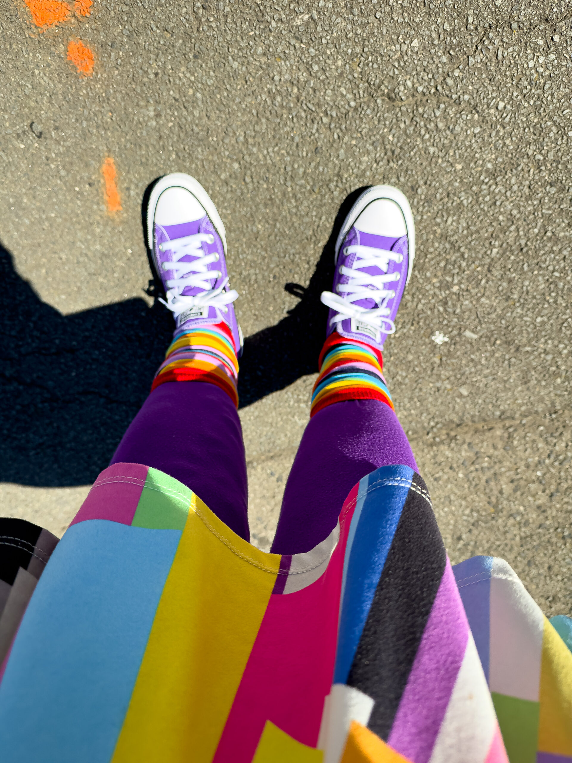 Looking down at my feet. I am wearing purple shoes, rainblow leg warners over purple leggings and a multicoloured skirt