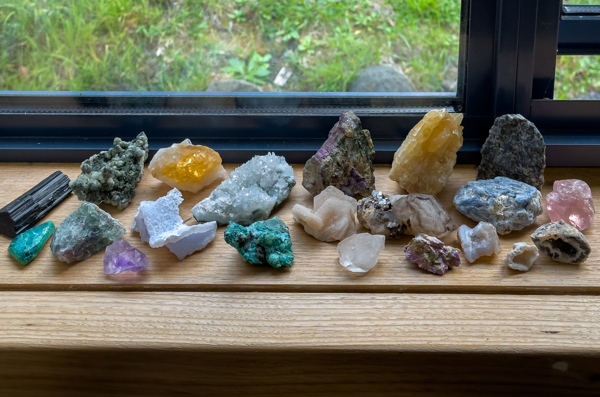 A collection of rock specimens sitting on wooden window sill