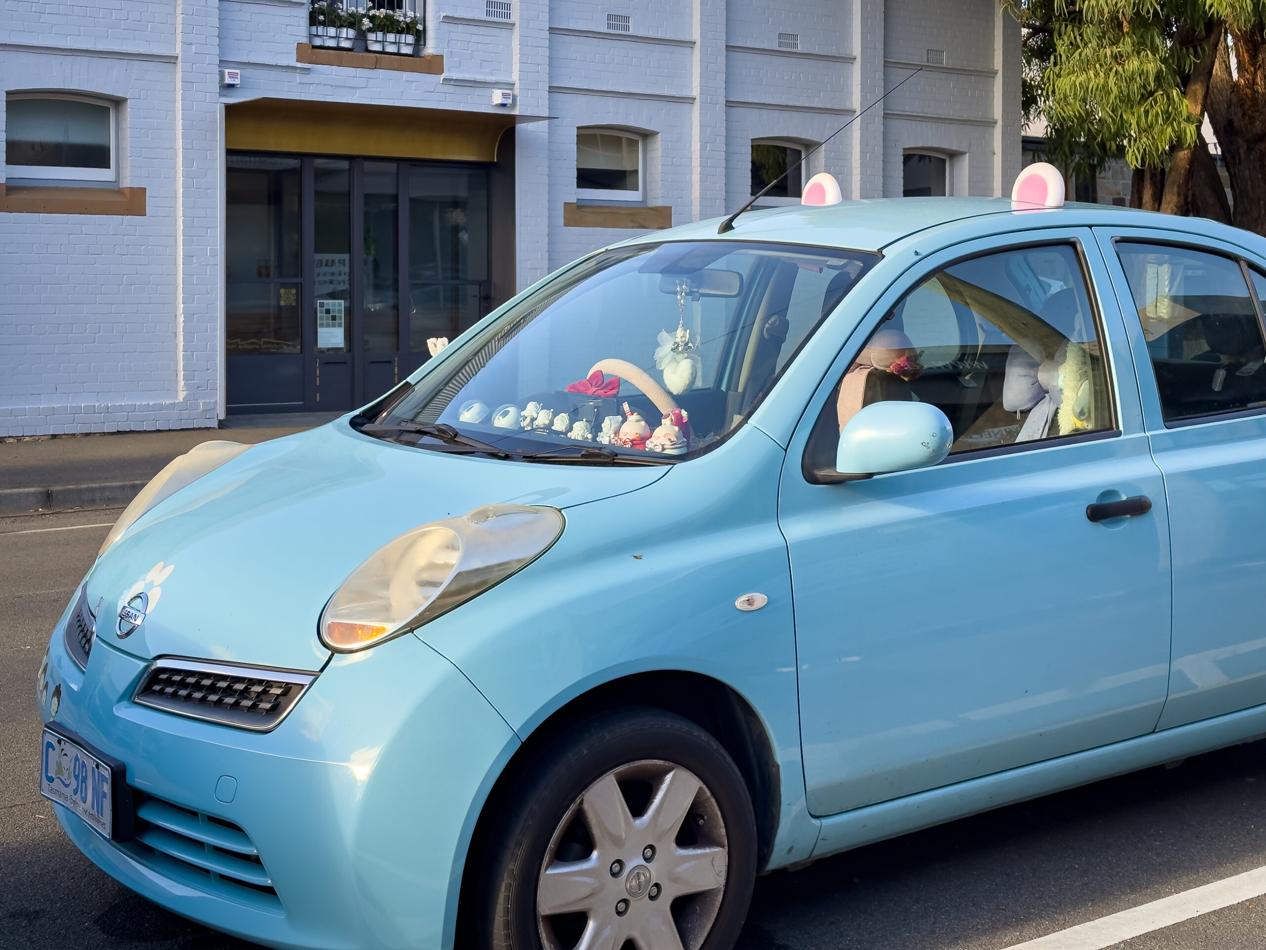 A blue car dressed up as a mouse with mouse ears