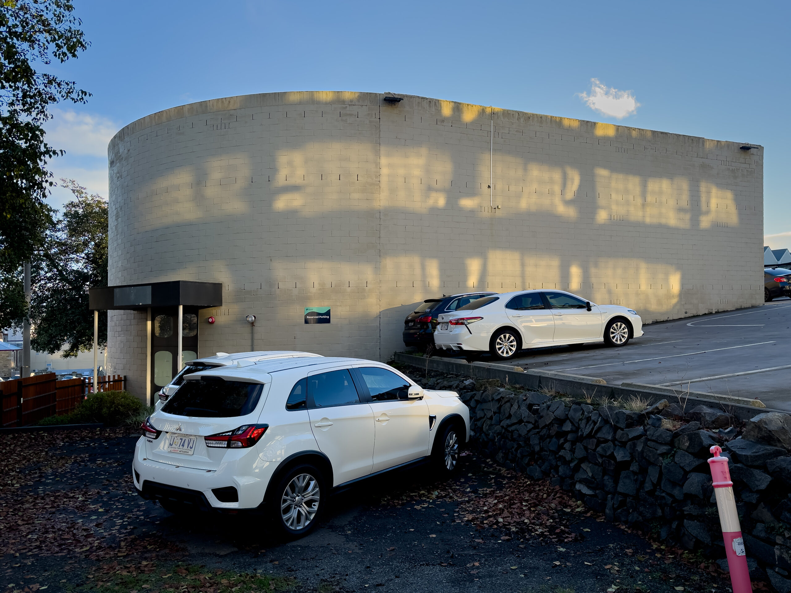 A rounded concrete building with some cool light effects on the facade